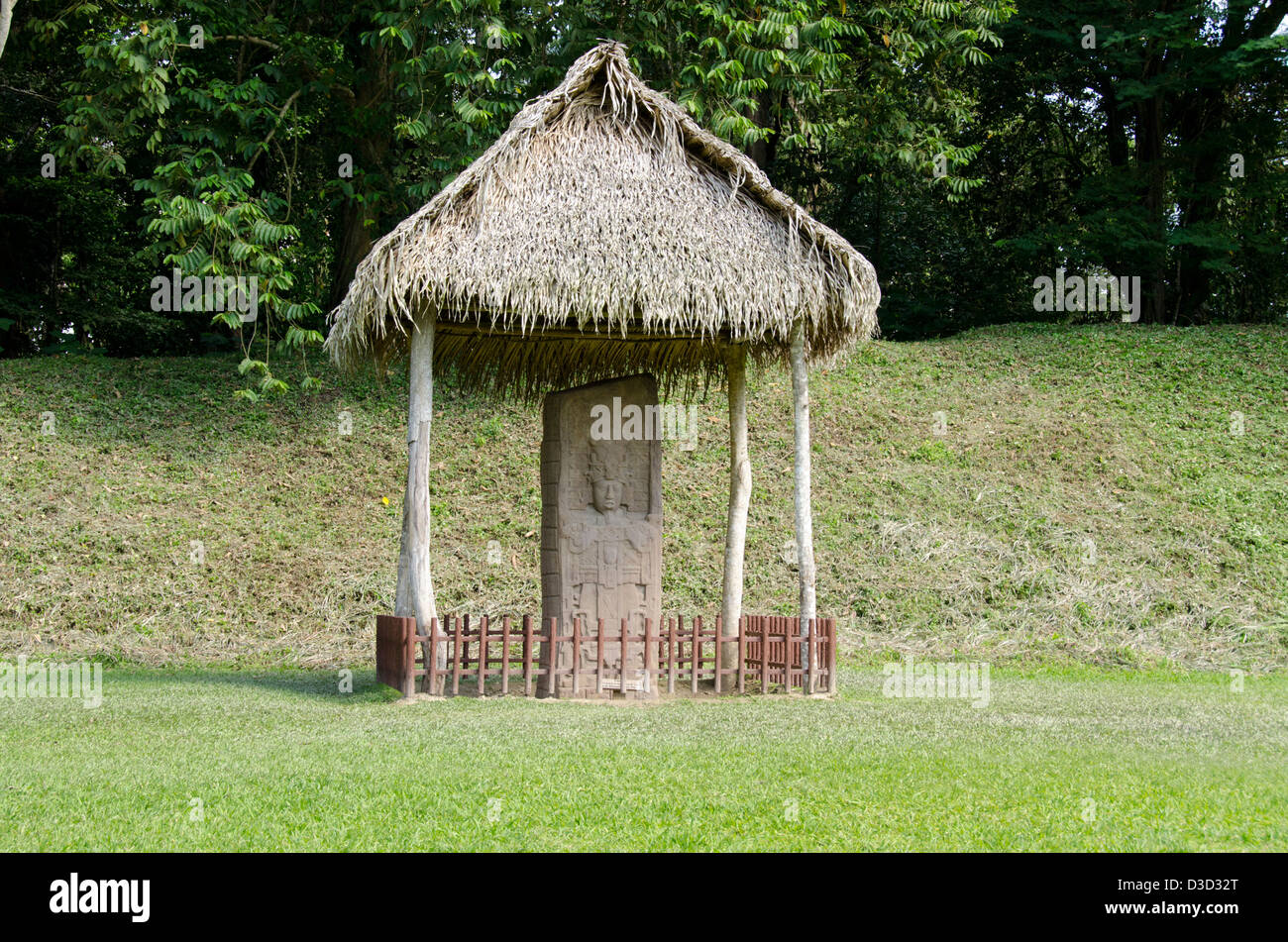 Guatemala, Quirigua rovine Maya parco archeologico (UNESCO) riccamente intagliato stele di pietra sotto la capanna con il tetto di paglia. Foto Stock