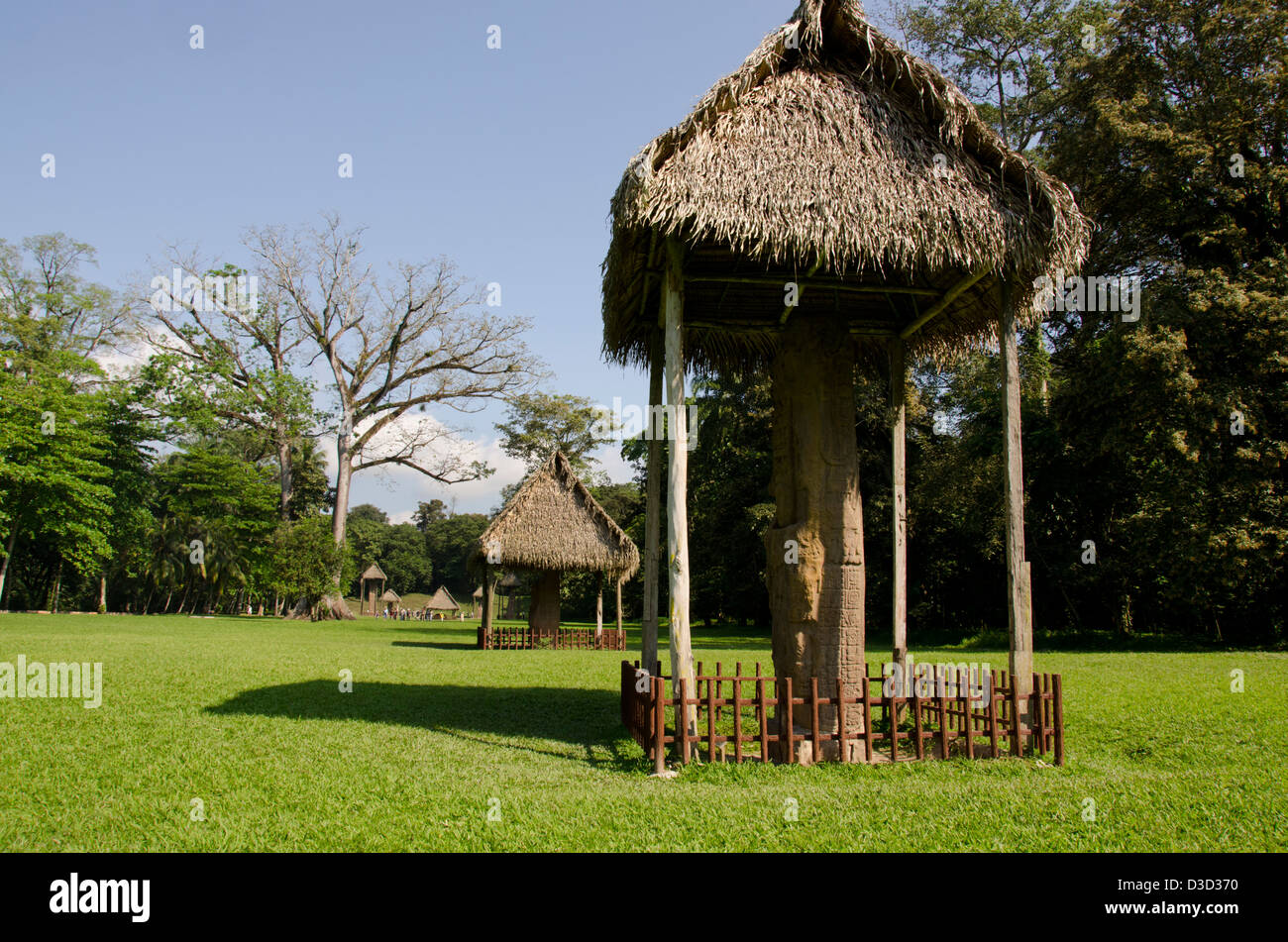 Guatemala, Quirigua rovine Maya parco archeologico (UNESCO), riccamente intagliato stele di pietra coperta da capanne. Foto Stock