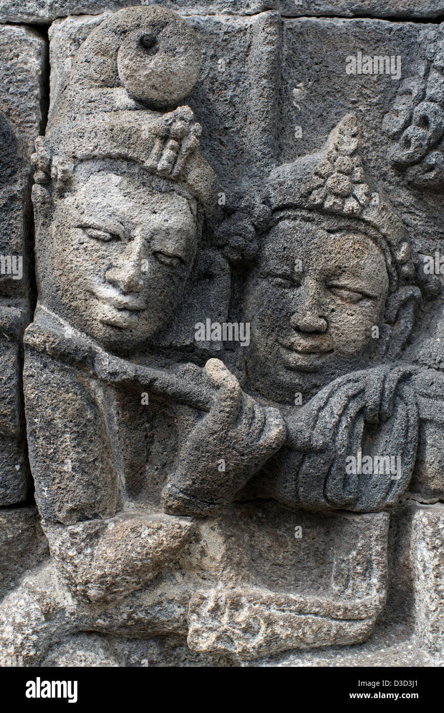 Scolpiti figurine buddista adornano le pareti del tempio Buddhista di Borobudur in Java, Indonesia Foto Stock