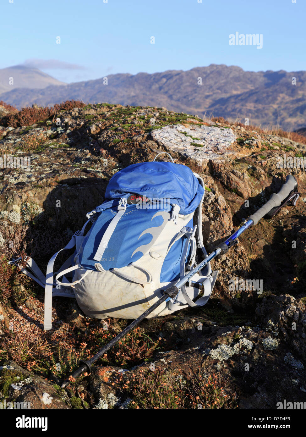 Blue Osprey zaino e Walking palo su una roccia nelle montagne del Parco Nazionale di Snowdonia, il Galles del Nord, Regno Unito, Gran Bretagna Foto Stock