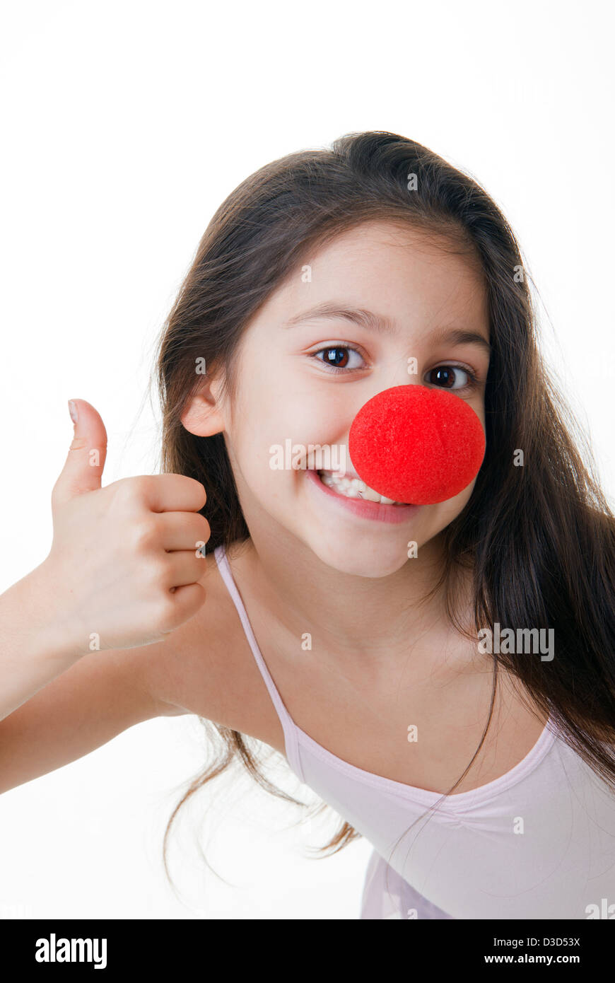 Bambino con red clown naso pollice in alto Foto Stock