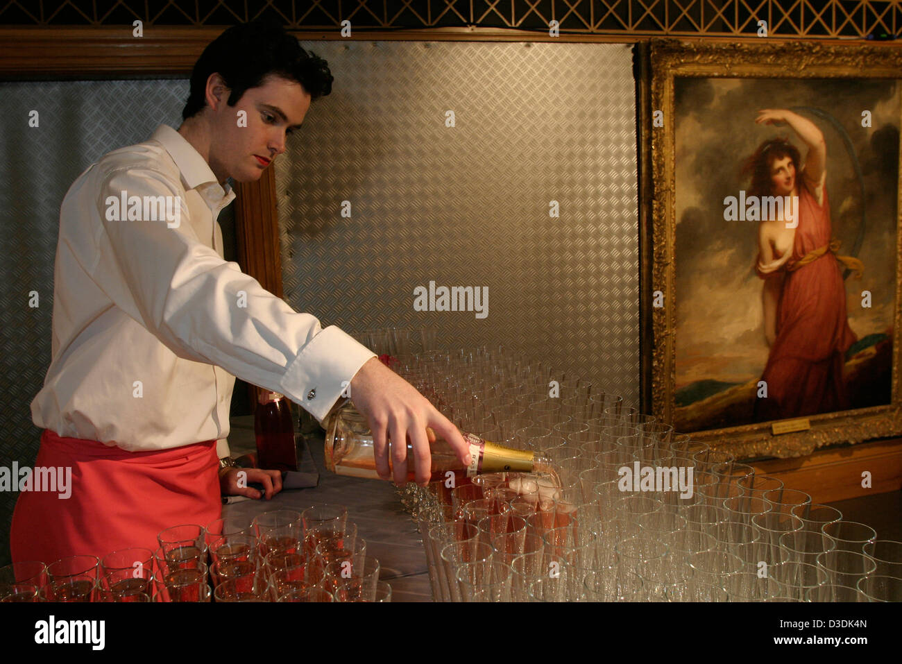 Londra, Inghilterra - Marzo 2004: Catering personale serve champagne rosa ad un'asta di Christie's house party Foto Stock