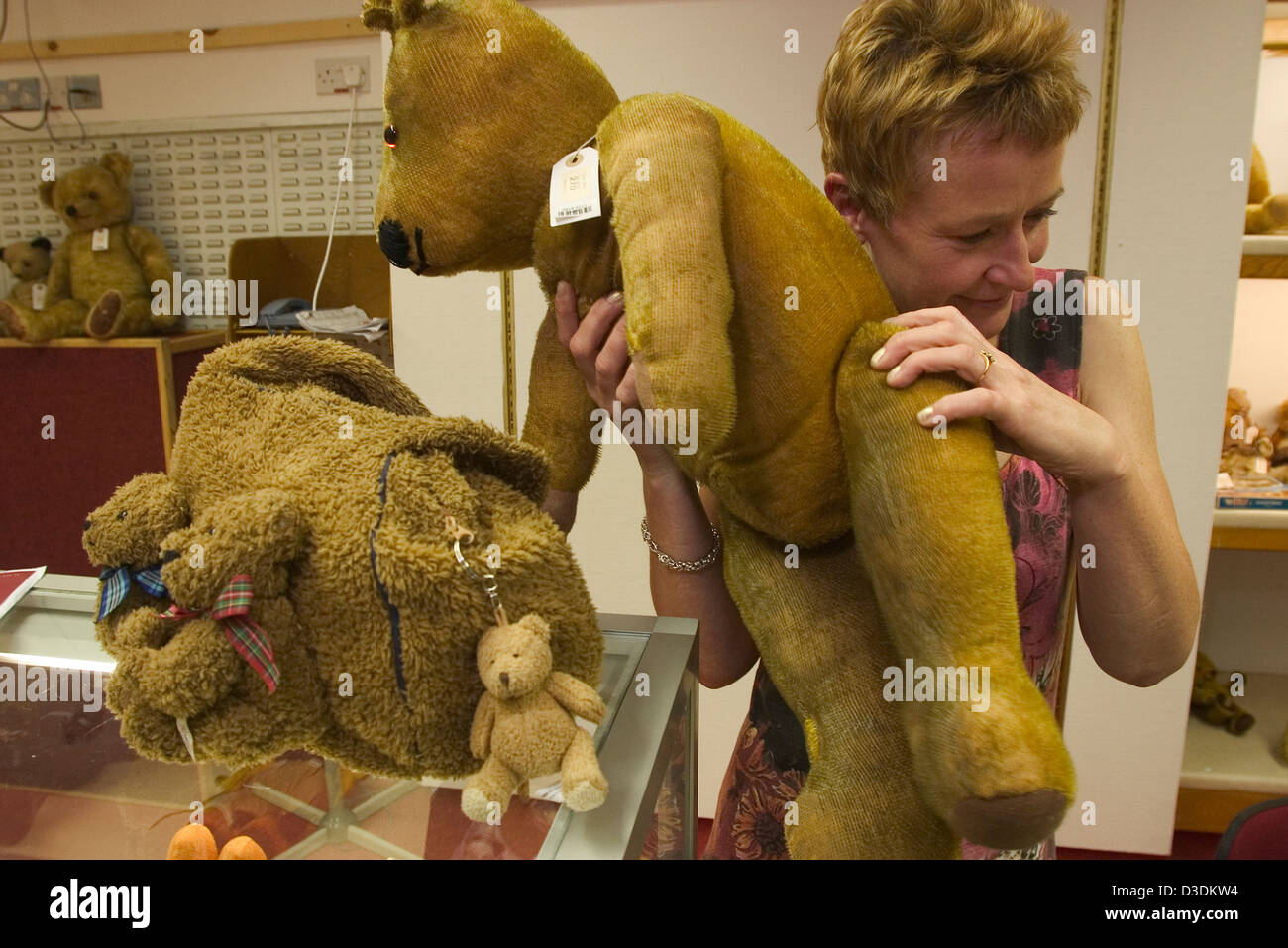 Londra, Inghilterra - GIUGNO 2004:un orsacchiotto collector ascolta per uno scricchiolio di articolazioni dell'anca durante l' esame di un orsacchiotto a una visualizzazione prima di un orso di peluche vendita a casa d'aste Christie's, South Kensington. Questo orsacchiotto non vendere. Foto Stock