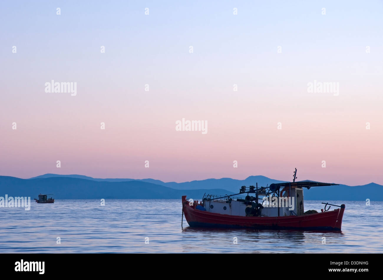 Barche da pesca sul Golfo Pagasitic al tramonto Foto Stock