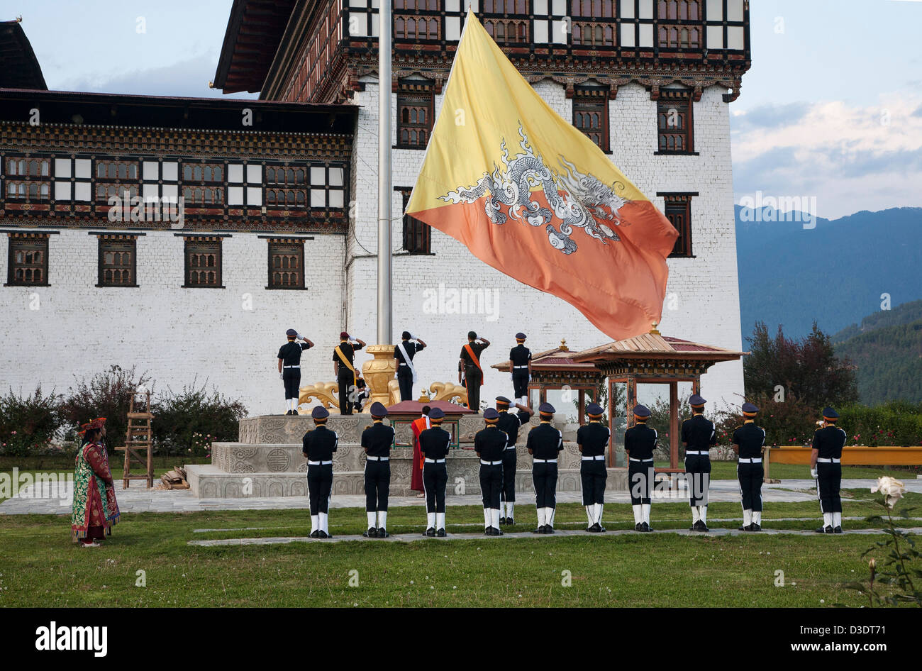 Il cerimoniale di abbassamento di bandiera al tramonto a Tashichho Dzong, sede del potere per il Bhutan a Thimphu. Foto Stock