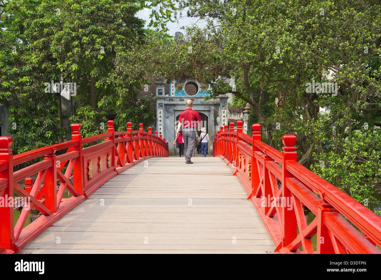 Uomo che cammina in Sun Huc Bridge Vietnam, Hanoi, Lago Hoan Kiem . Foto Stock