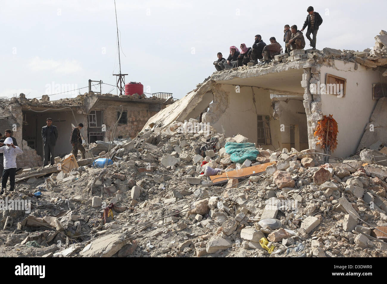 Le persone si mettono sul tetto di una casa distrutta dopo un presunto missile Scud attacco nel quartiere Hanano di Aleppo, Siria, 17 febbraio 2012. Secondo la libera esercito siriano, FSA informazioni 10 case sono state distrutte mediante l esplosione del razzo. Foto: Jan A. Nicolas Foto Stock