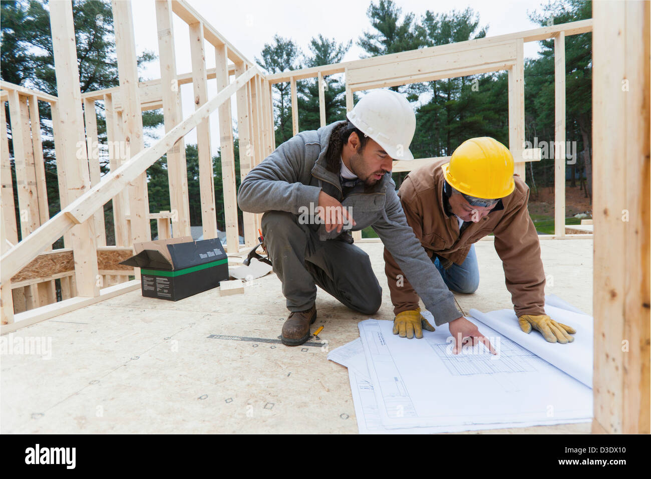 Supervisore di costruzione revisione home piano di progettazione con un falegname Foto Stock