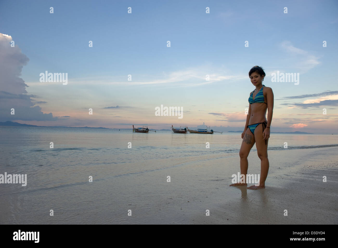 Phi Phi Islanda, Thailandia, una donna in un bikini godendo la serata in spiaggia Foto Stock