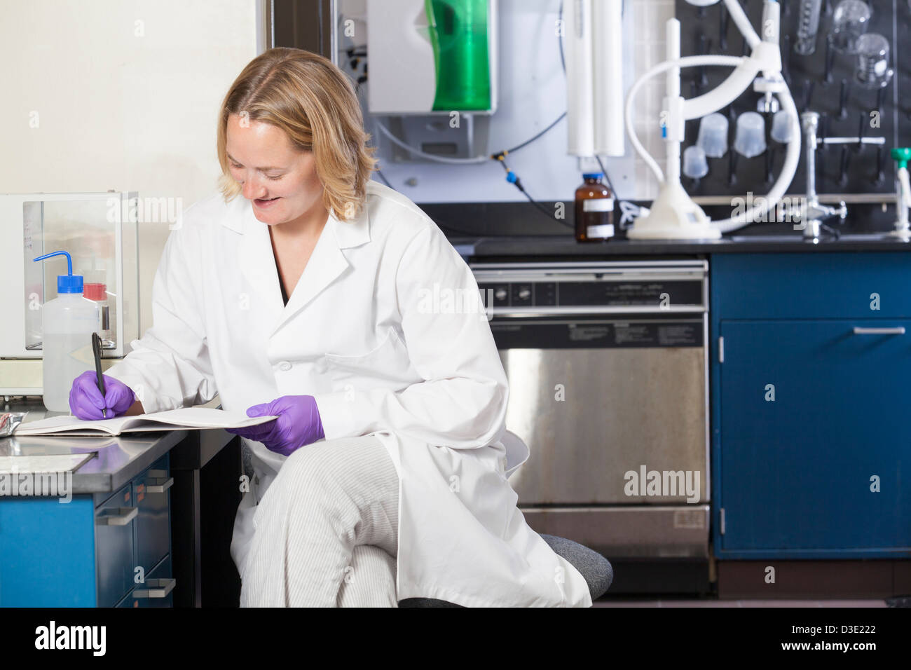 Laboratorio di uno scienziato chimico di registrazione dei dati di analisi in un laboratorio Foto Stock