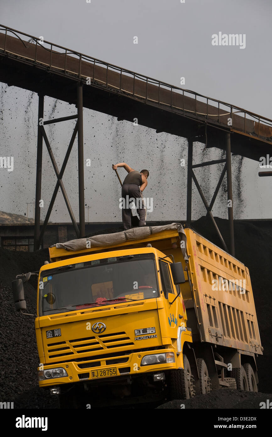 DATONG, nella provincia di Shanxi, Cina - Agosto 2007: un carbone camionista livelli un carico fresco di carbone a una miniera di privato. Foto Stock