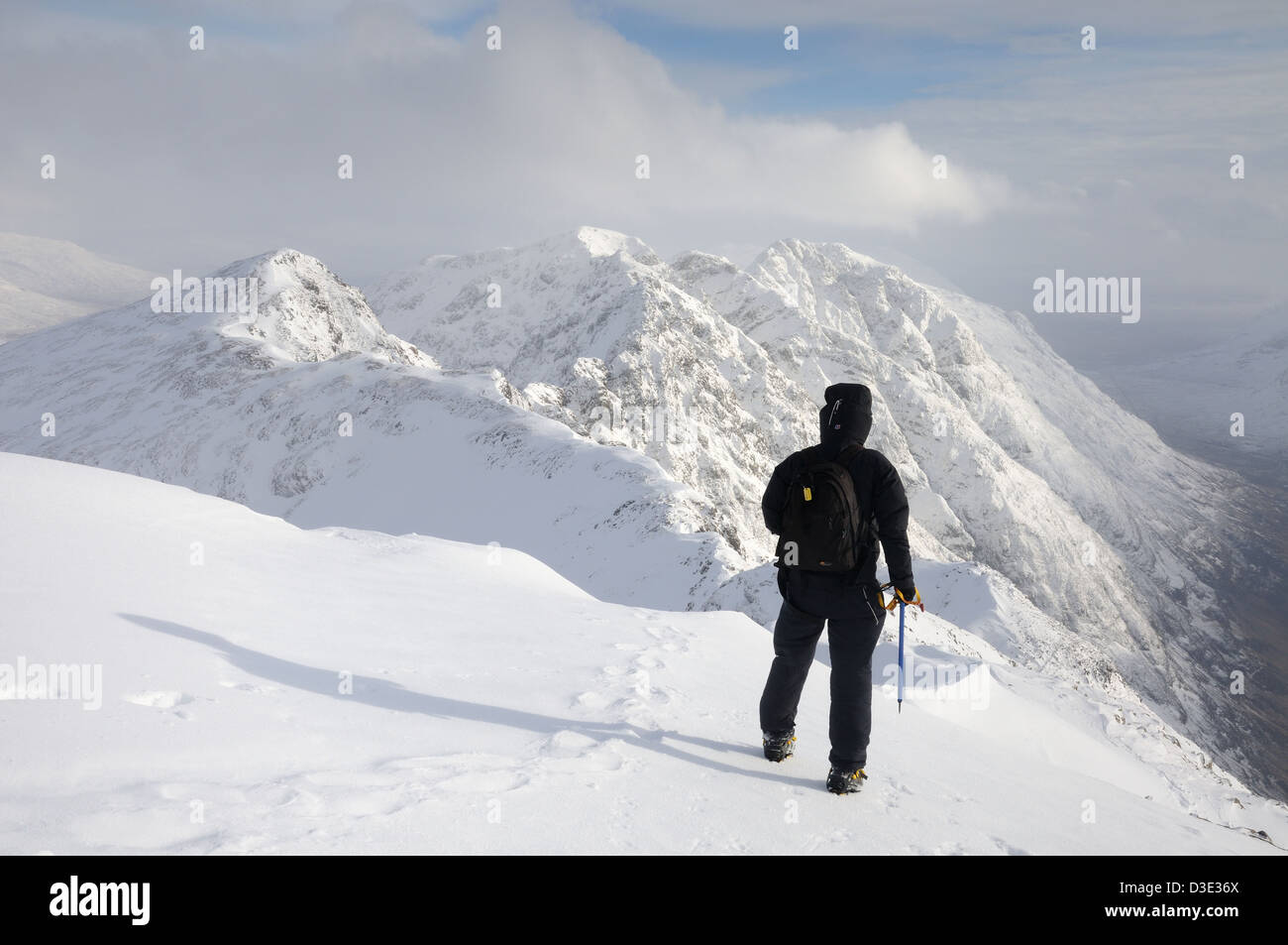 Walker sul vertice di Sgorr nam Fiannaidh, guardando verso la stretta Aonach Eagach ridge, Glencoe, Highlands scozzesi Foto Stock