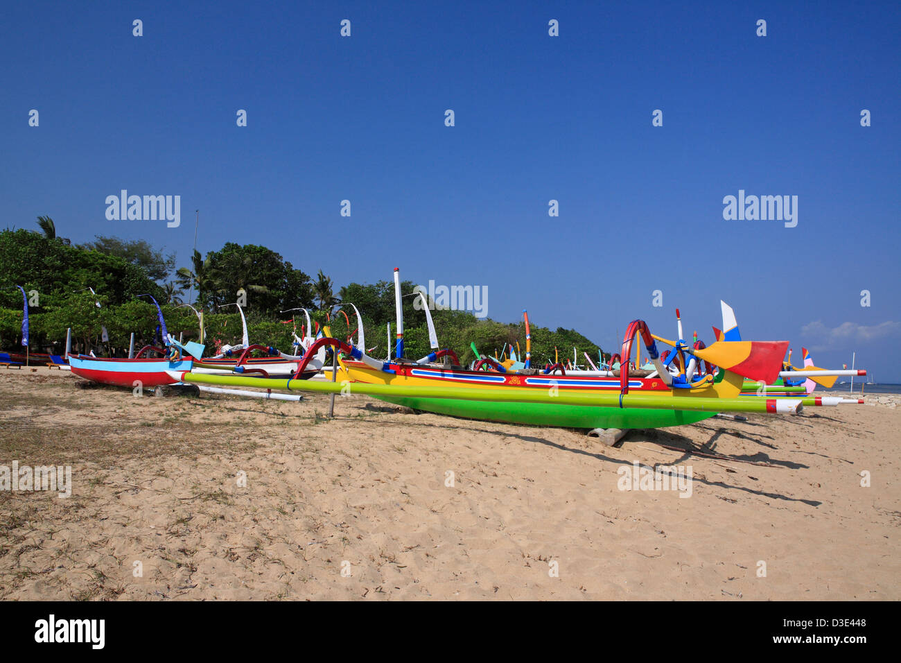 Vivacemente colorate barche da pesca, chiamato Jukungs, allineate sulla spiaggia di Sanur, Bali, Indonesia Foto Stock