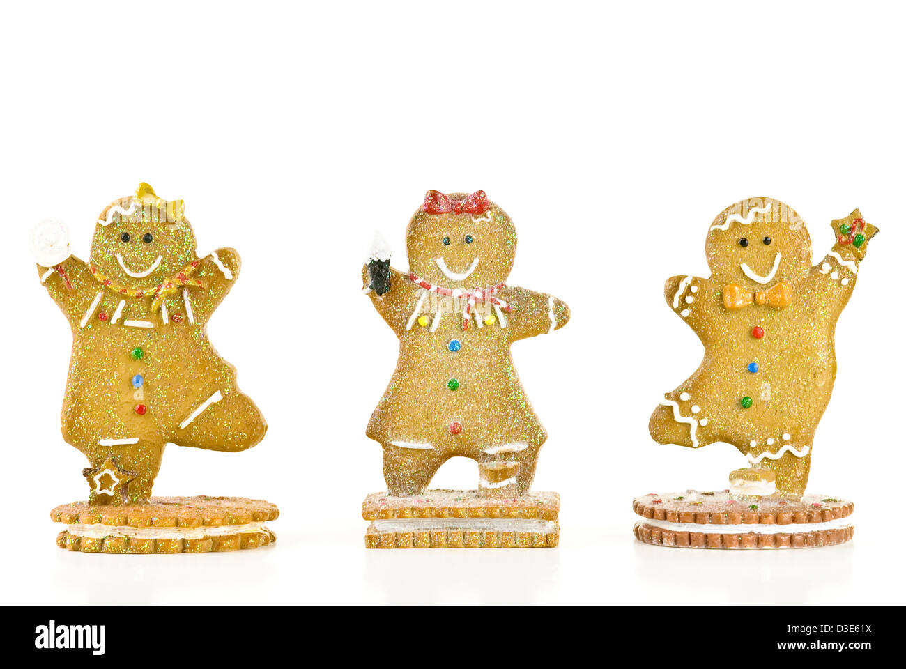 Tre glittery holiday gingerbread cookies isolati su sfondo bianco. Foto Stock