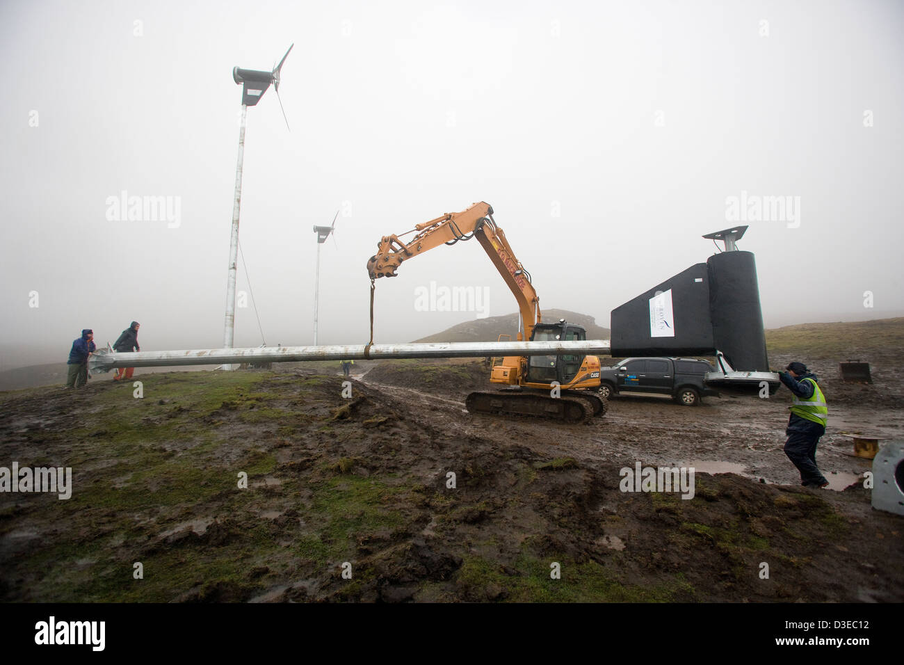 Isola di Eigg, Scozia - 1 Novembre 2007: i lavoratori spostare la terza torre a turbina eolica in posizione. Foto Stock