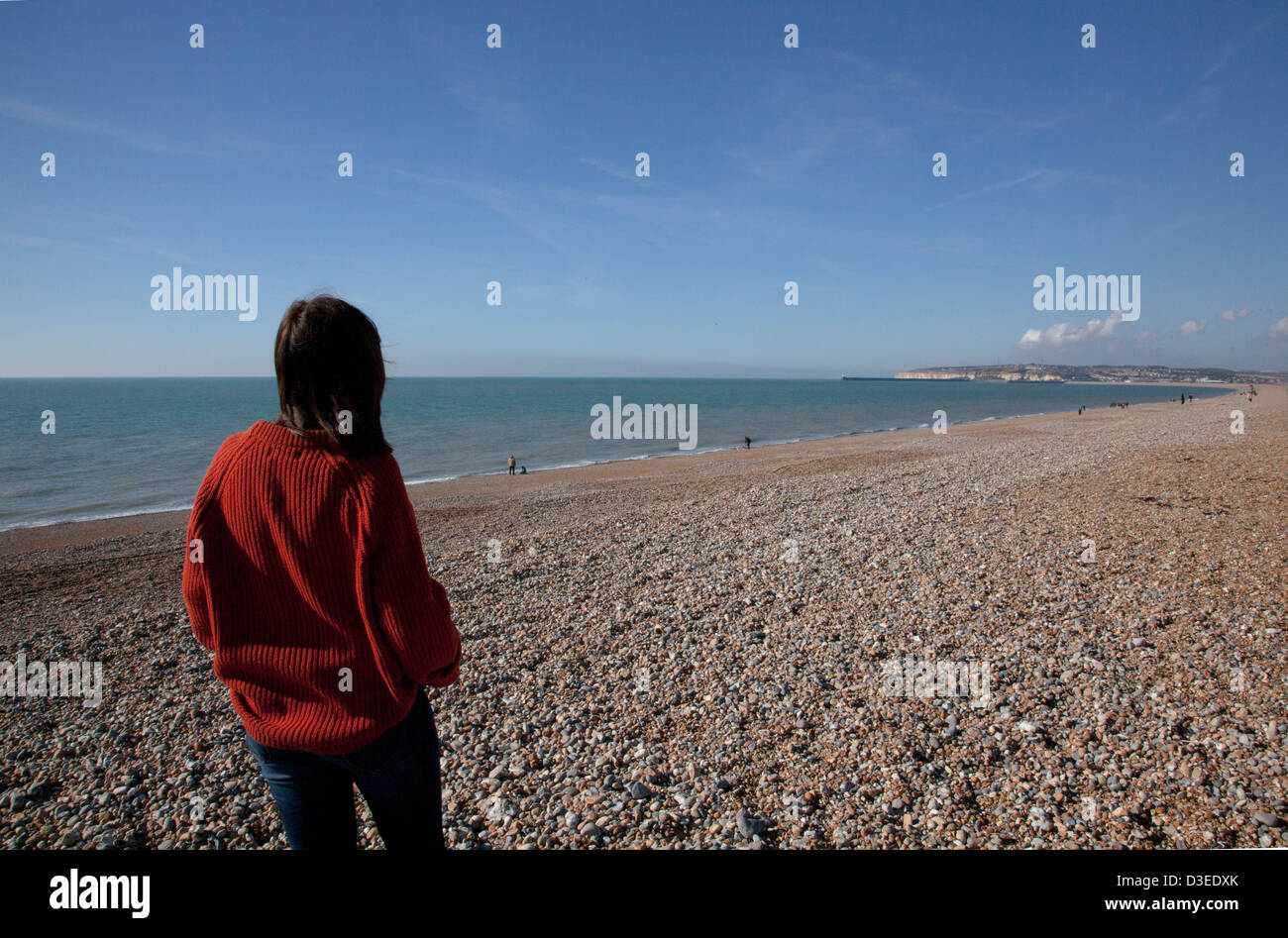 Torna alla telecamera colpo di una donna che indossa un chunky uomini ponticello affacciata sul mare, a significare la perdita di una persona cara. Foto Stock