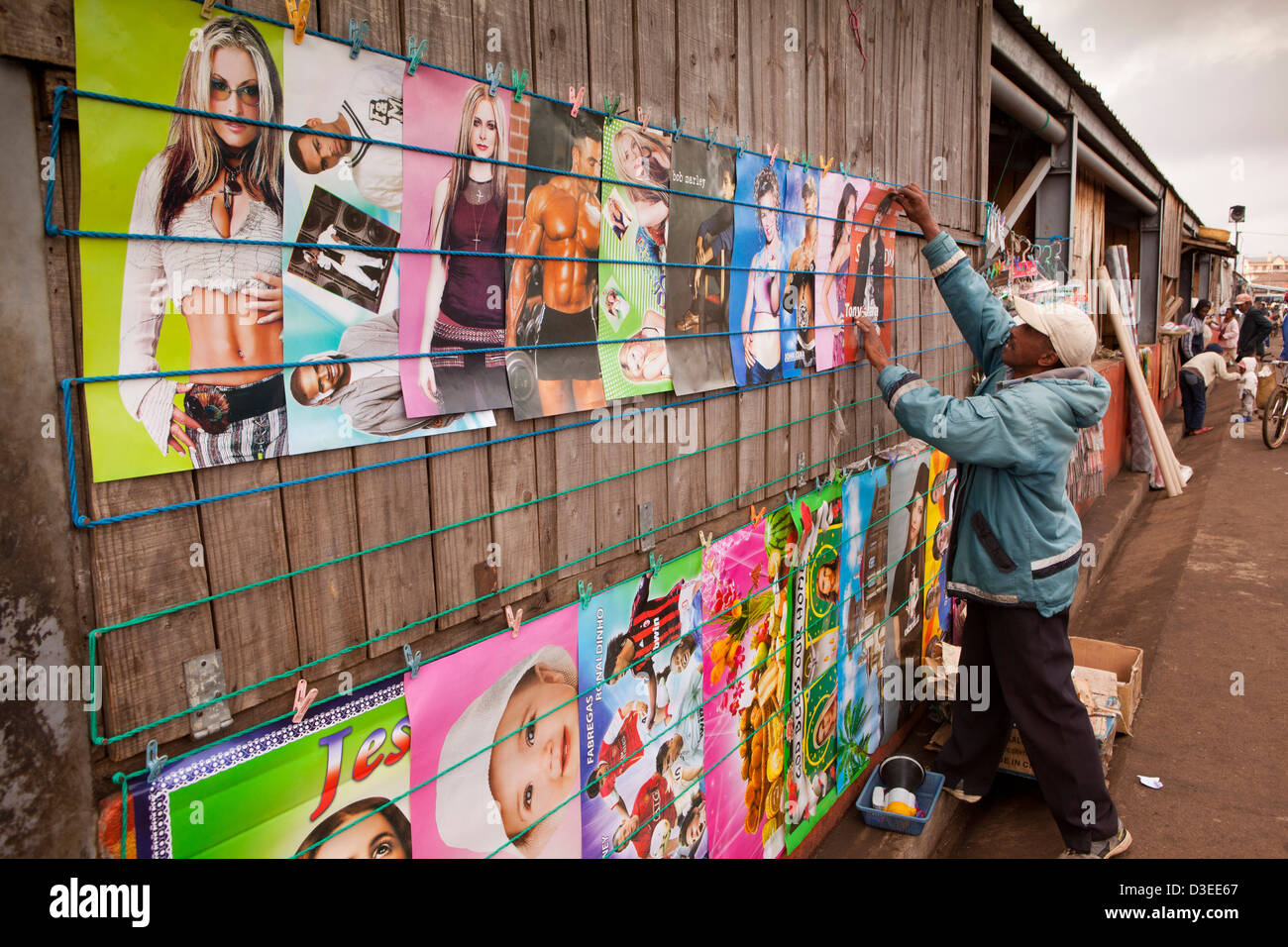 Madagascar, Antsirabe, Marche Sabotsy Mercato, uomo appeso fuori poster colorati per vendere Foto Stock