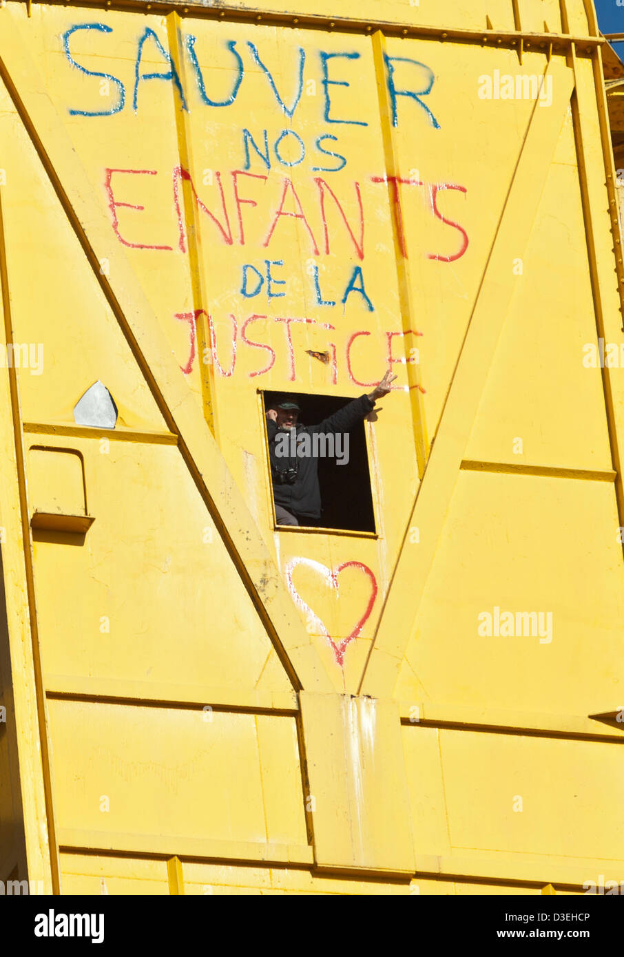 Serge a Charnay gesti per persone al di sotto della sua posizione in un alto 40 metri gru di cantiere a Nantes, Francia, 18 febbraio 2013. A Charnay risalito la gru il 16 febbraio per protestare contro una decisione del tribunale negando lui accesso al suo figlio. Foto Stock