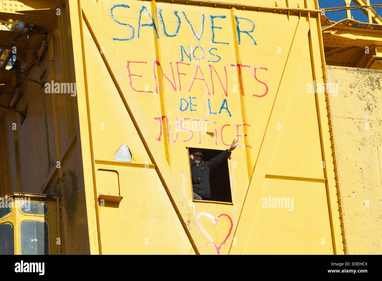Serge a Charnay gesti per persone al di sotto della sua posizione in un alto 40 metri gru di cantiere a Nantes, Francia, 18 febbraio 2013. A Charnay risalito la gru il 16 febbraio per protestare contro una decisione del tribunale negando lui accesso al suo figlio. Foto Stock