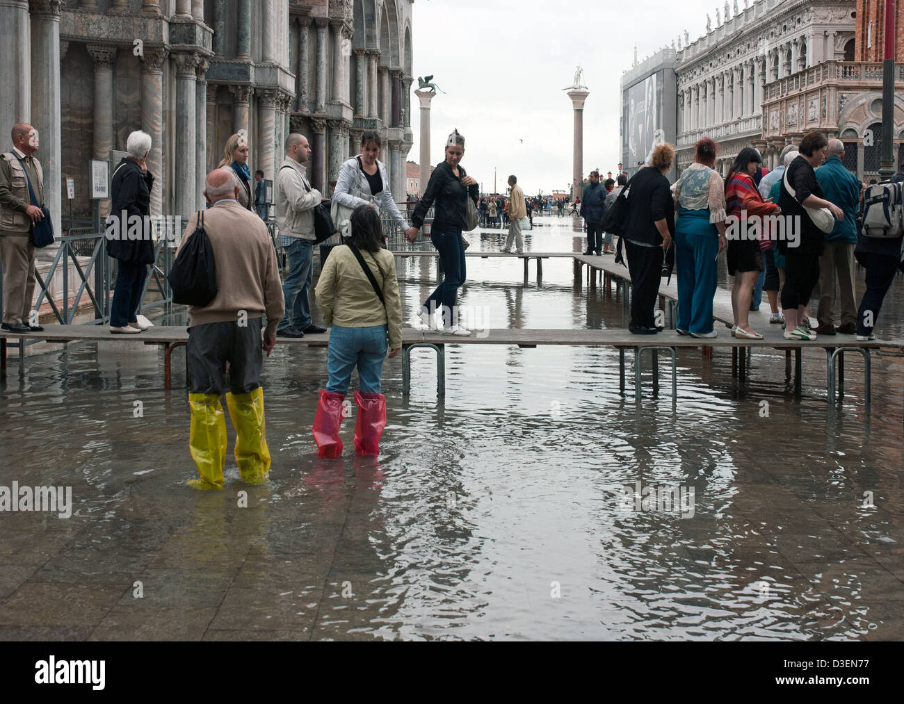 I turisti che visitano la cattedrale di San Marco allineando sulle piattaforme su acqua alta a Venezia Foto Stock