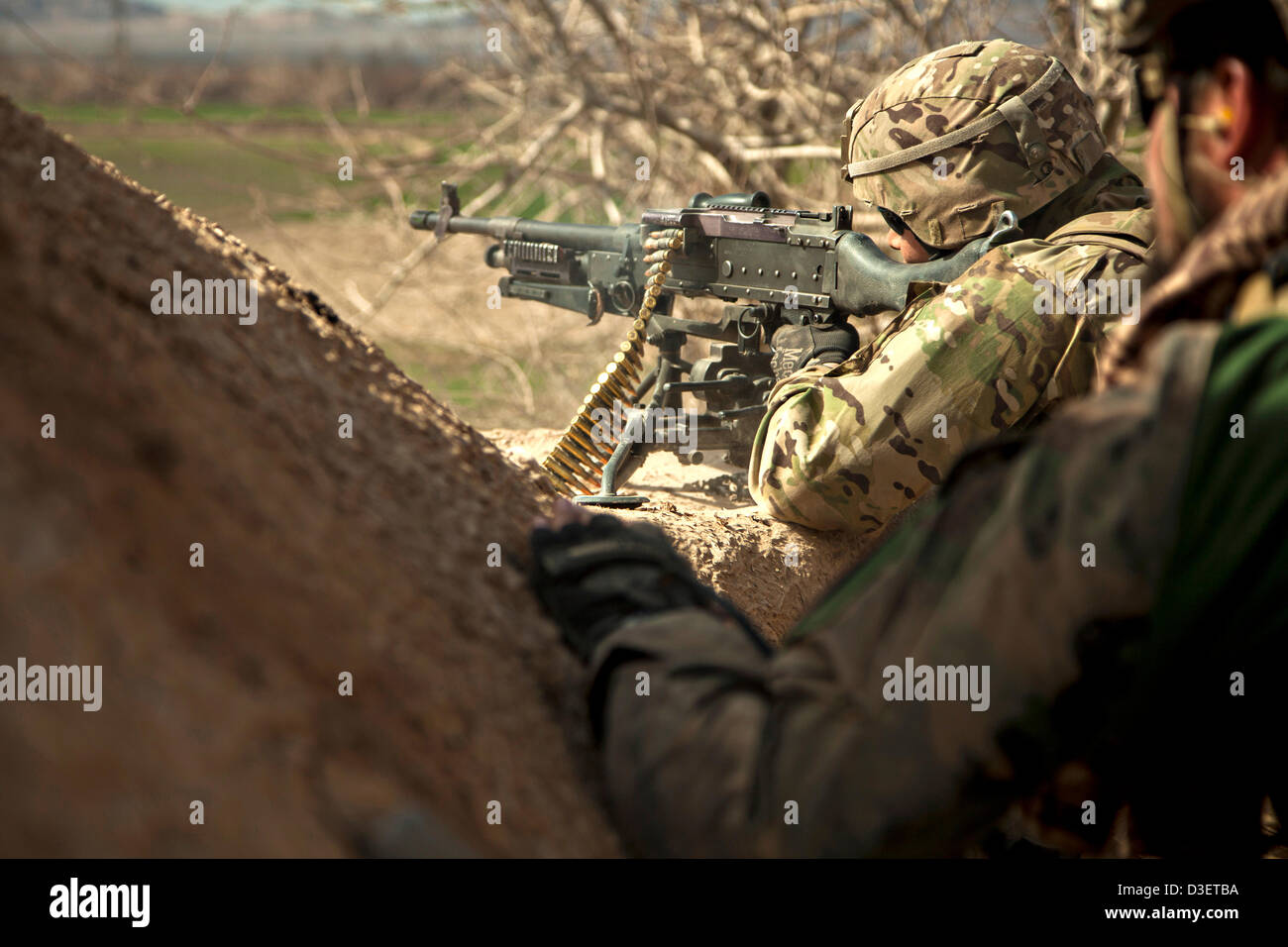 Un marine statunitense continua a guardare con una macchina pesante pistola come esercito nazionale afghano delle forze speciali militari di ritorno da una pattuglia di combattimento Febbraio 17, 2013 nella provincia di Herat, Afghanistan. Il presidente Barack Obama ha annunciato durante lo stato dell'Unione che metà delle forze americane in Afghanistan si ritirerà da inizio 2014. Foto Stock