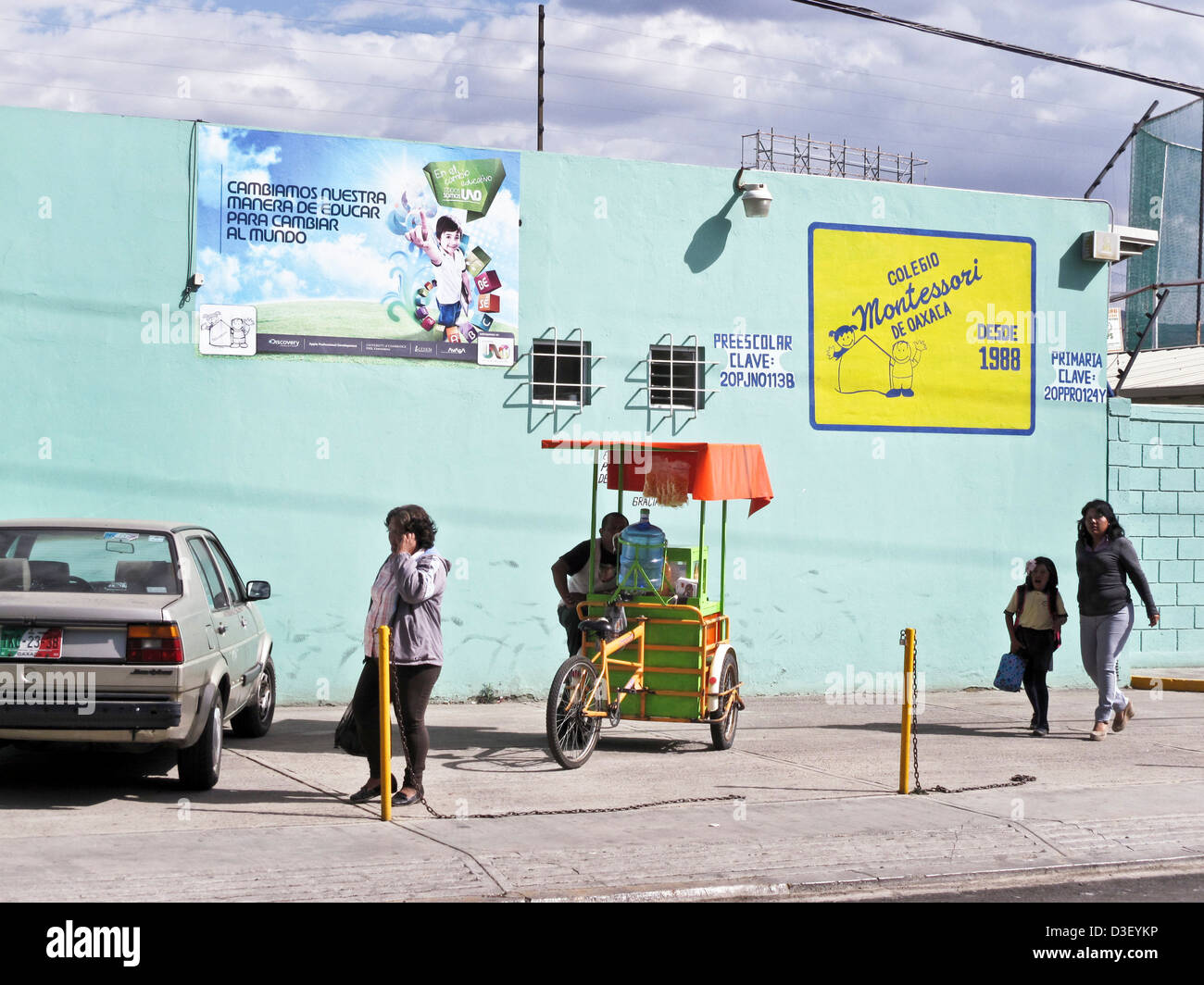 Ice Cream vendor con colorati carrello attende per scolari a lasciare la scuola Montessori con i genitori dopo le classi Oaxaca Messico Foto Stock