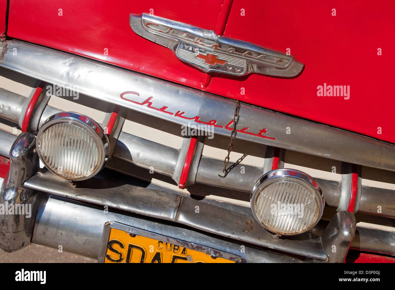 Chiusura del logo, il paraurti e la griglia del vecchio rosso degli anni cinquanta vintage americano auto Chevrolet / Yank serbatoio in Trinidad, Cuba, Caraibi Foto Stock