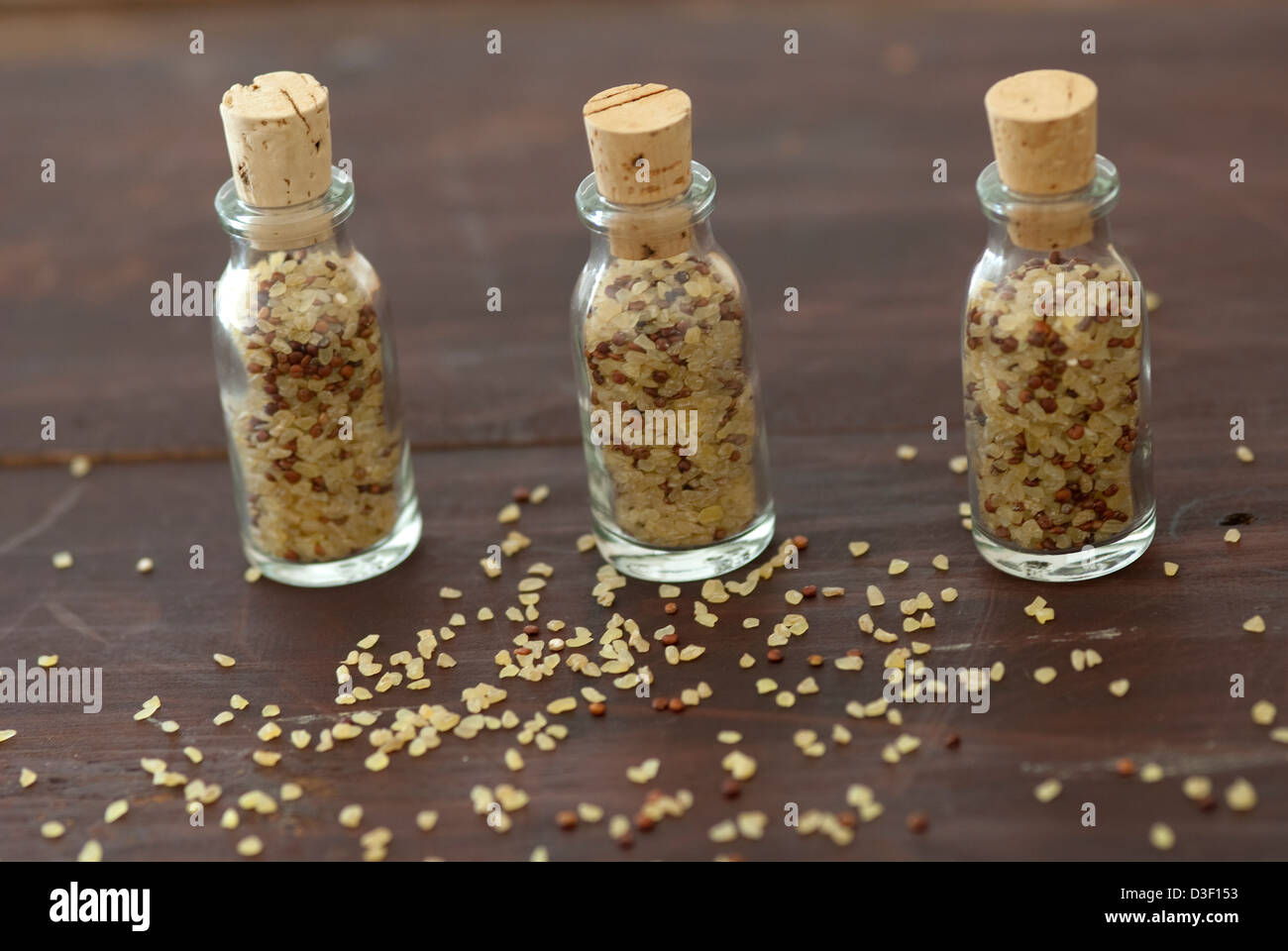 Tre piccoli tappo bottiglie contenenti bulgar il frumento e la quinoa Foto Stock