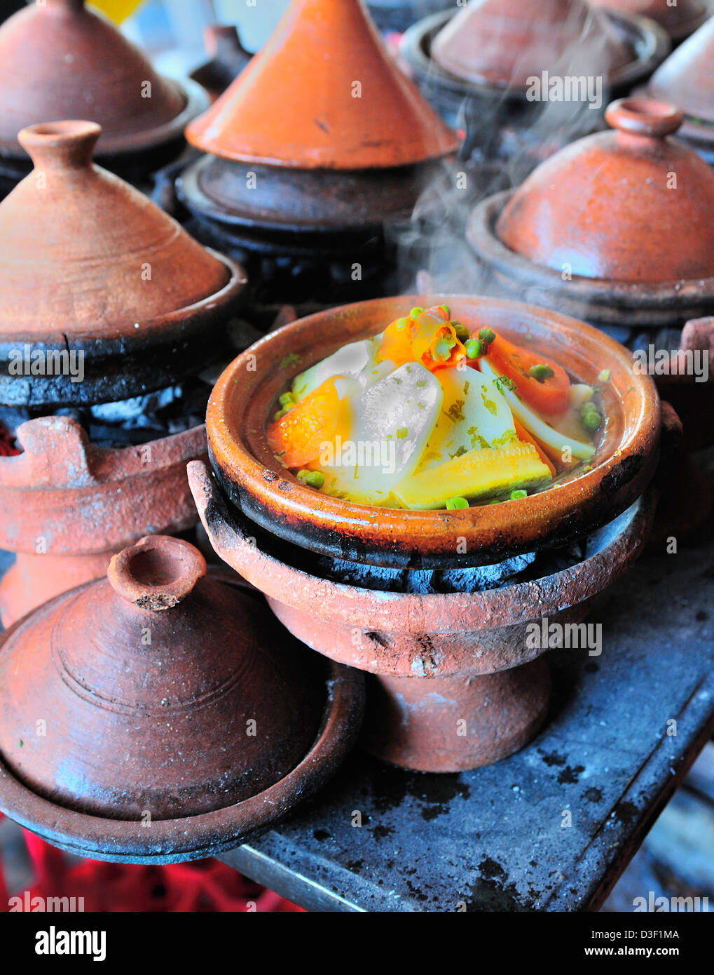 Tagine pentole di terracotta con tagine vegetale che è cotto su un fuoco di carbone in una bancarella di mercato vicino Jemaa el fna, Marrakech, Marocco Foto Stock