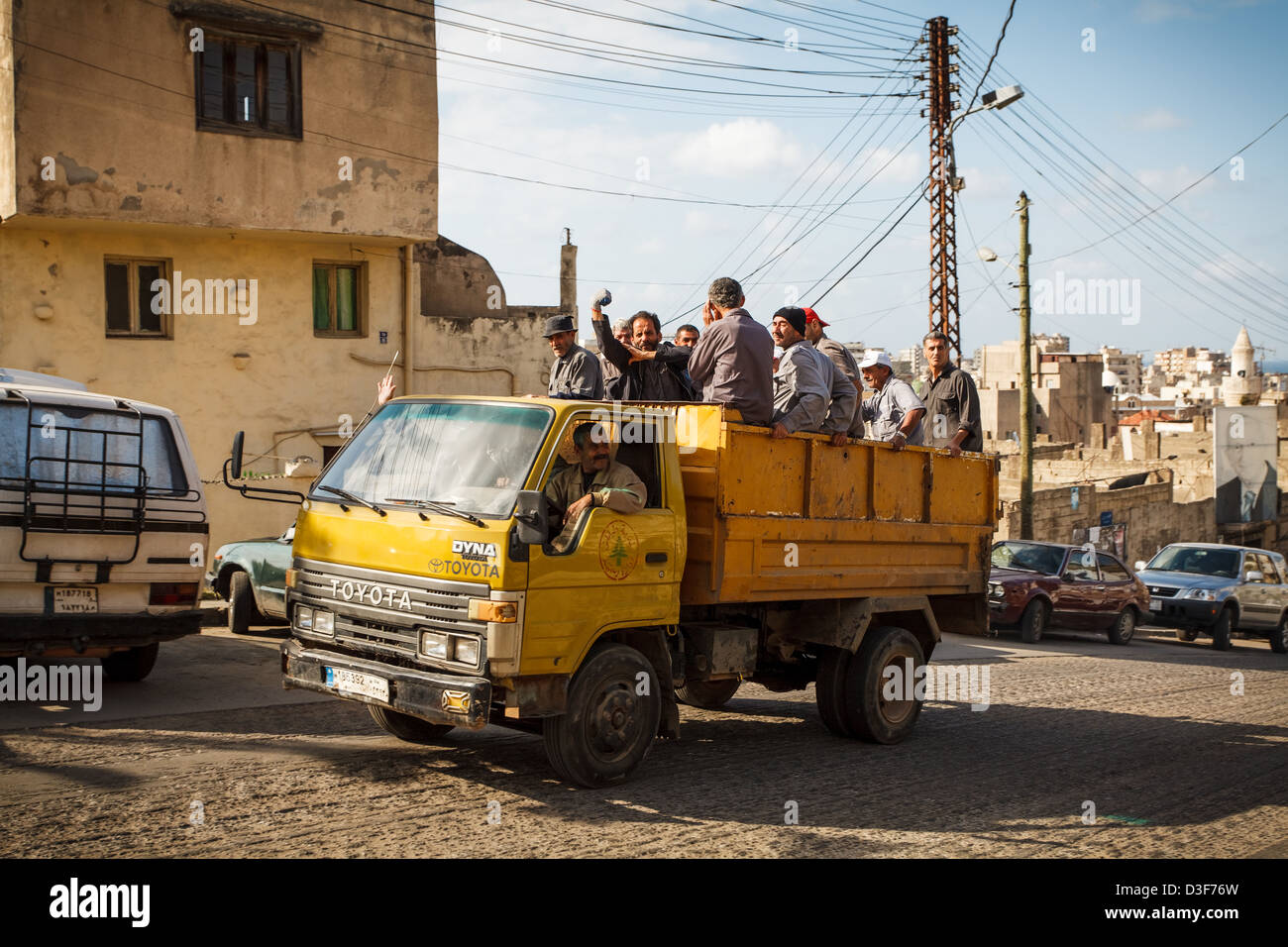 Giorno operai in un carrello dà il finder per il personale dell'esercito la telecamera verso sinistra. Tripoli, nel nord del Libano. Foto Stock