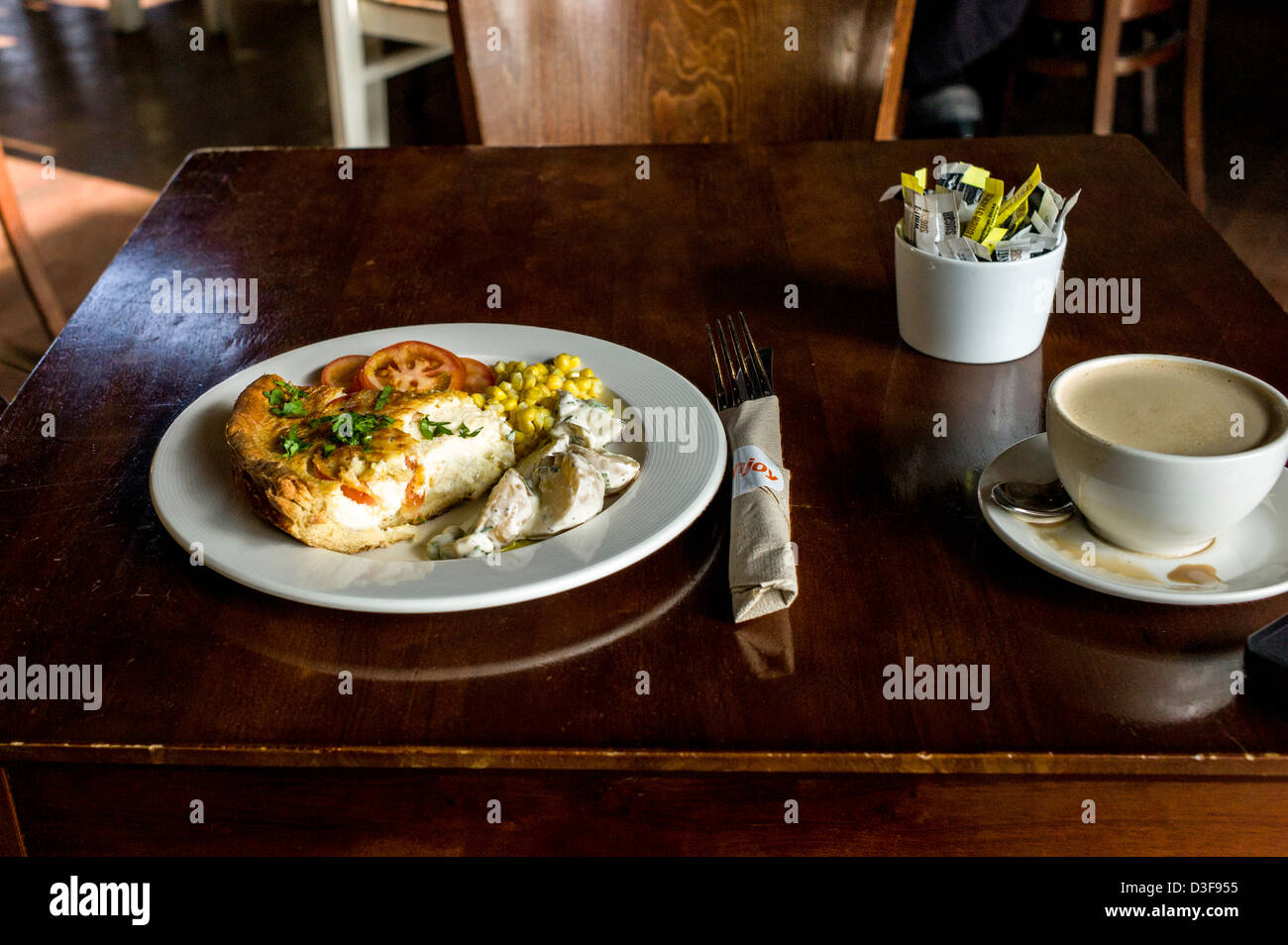 Pranzo insalata con quiche, insalata di patate, mais dolce e pomodoro con un caffè a Hackney Empire, East London Foto Stock