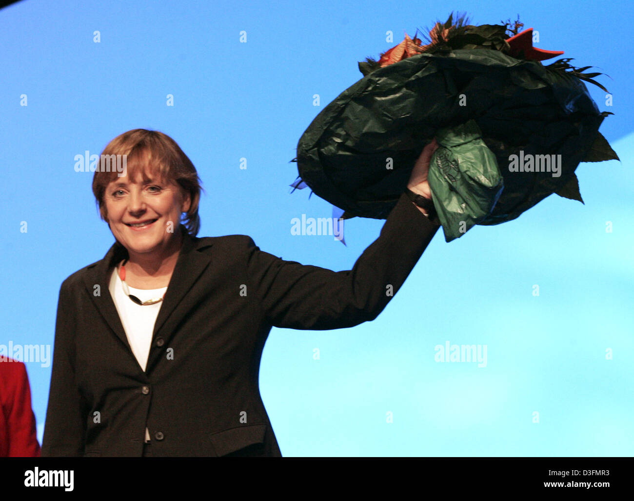 (Dpa) - Angela Merkel, leader del cristiano democratico tedesco Unione (CDU), sorregge un mazzo di fiori dopo essere stato rieletto durante la CDU del XVIII Congresso di partito a Duesseldorf in Germania, 6 dicembre 2004. In una deludente la rielezione, il 50-anno-vecchio Merkel ha ricevuto solo 88.41 per cento dei voti. Due anni fa di lei è stato eletto con il 93,7 per cento. Il congresso di partito prende pl Foto Stock