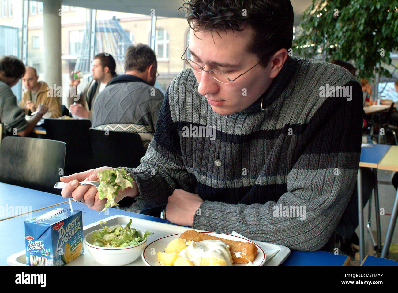(Dpa) - Uno studente mangia alla comunità del collegio degli studenti sala da pranzo a Francoforte, Germania, 19 novembre 2004. Foto Stock