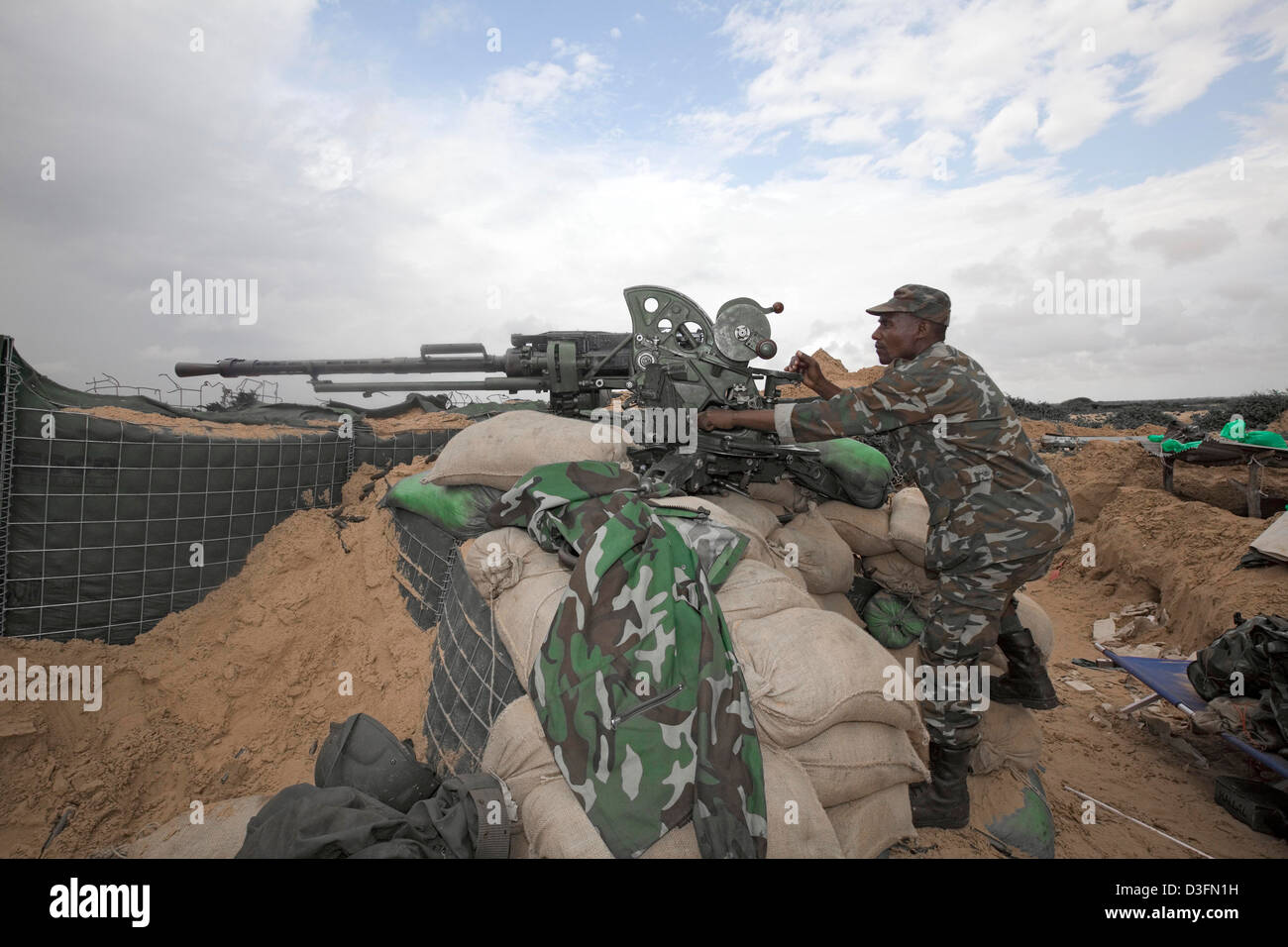 Un'AMISOM burundesi soldato manning un cannone di artiglieria di collocamento sulla destra il fronline a Daynille quartiere sulla periferia del MOG Foto Stock