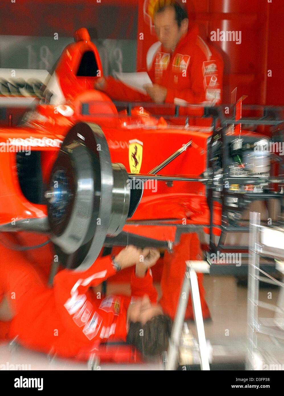 (Dpa) - Un meccanico di fili in corrispondenza del fondo di una formula one racing car in Ferrari pit in A1-Ring racetrack vicino a Zeltweg, Austria, 15 maggio 2003. Il racing team a prepararsi per il Gran premio d'Austria che è la sesta gara che conduce fino alla formula uno worldchampionship e che avrà inizio il 18 maggio 2003. Foto Stock