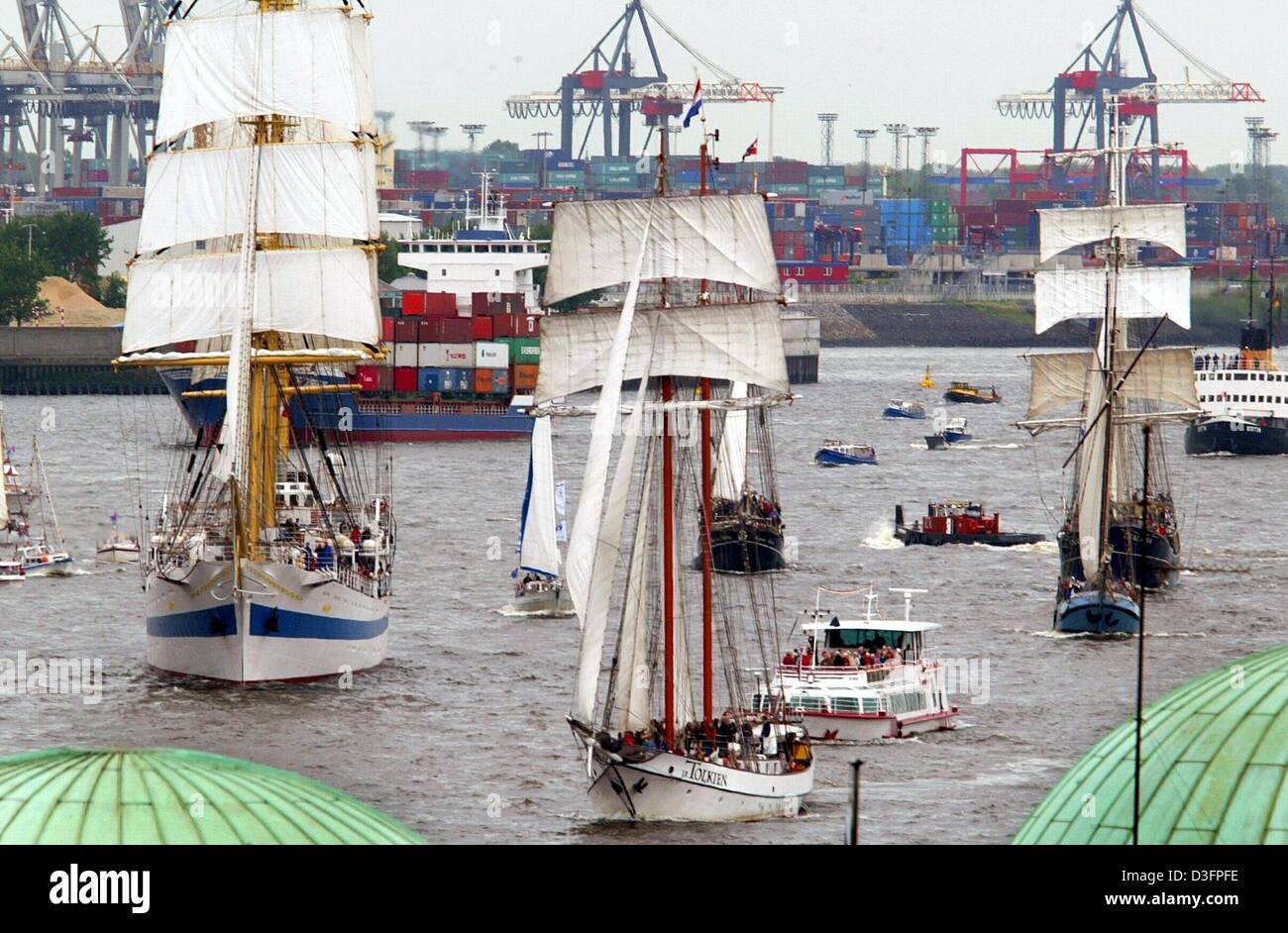 (Dpa) - Tre grandi barche a vela (L) "IR", il "J.R.Tolkien' e il 'Thalassa", accompagnata da piccole imbarcazioni a vela lungo il fiume Elba e passato fronte del porto di Amburgo, Germania, 9 maggio 2003. La zona tra Amburgo porto della città e il museo del porto fu trasformata in un folk e fiera festival che celebra il 814th anniversario di Amburgo del porto. Foto Stock