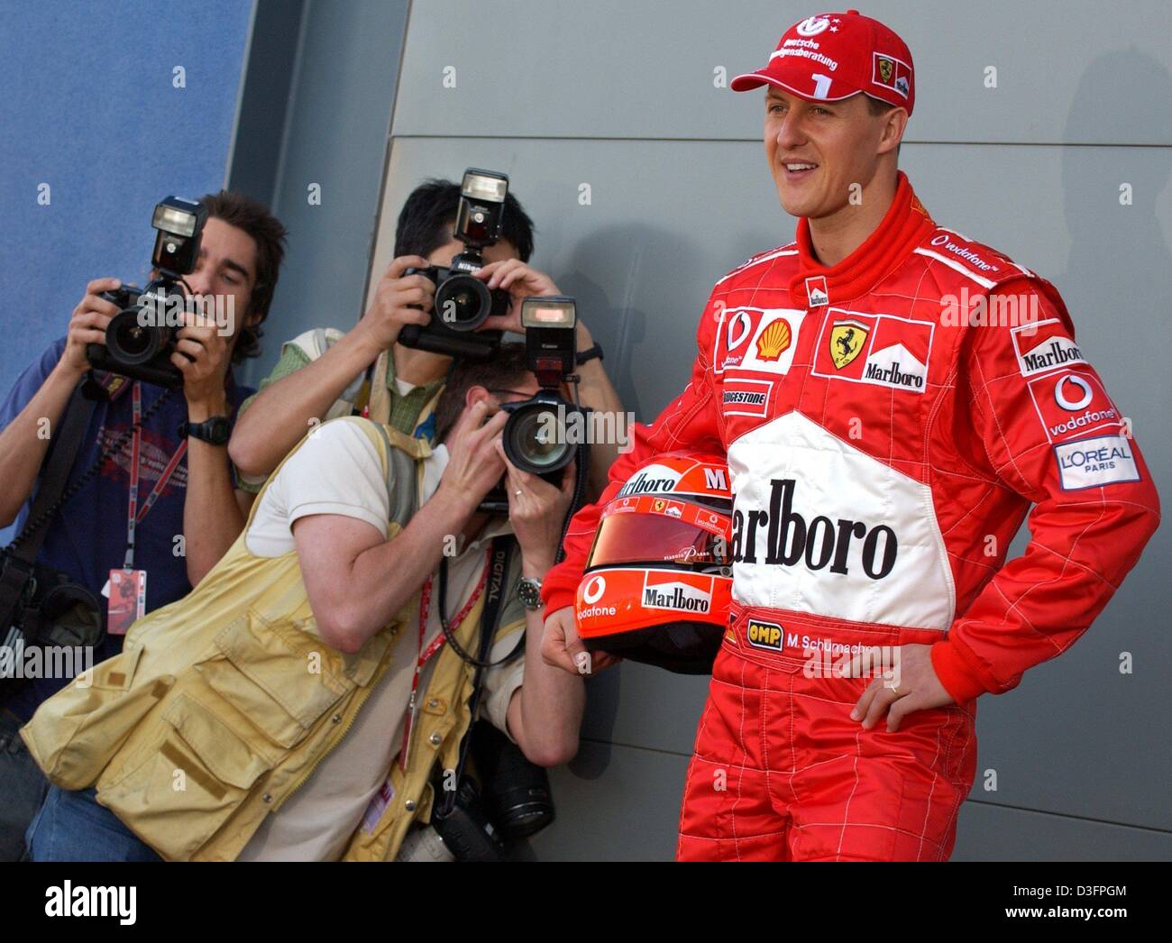 (Dpa) - tedesco di formula one champion Michael Schumacher sorrisi e comporta per i fotografi di occupato e le loro macchine fotografiche in pista a Melbourne, Australia, 6 marzo 2003. La stagione di Formula Uno 2003 aprirà questo fine settimana a Melbourne il 9 marzo 2003. Foto Stock