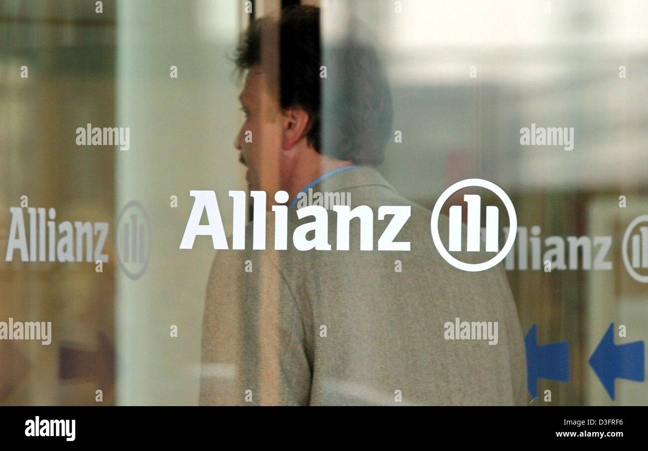 (Dpa) - Un dipendente di Allianz AG, i servizi finanziari e il fornitore di servizi assicurativi, sorge dietro il vetro di una porta girevole con il logo della società su di esso in corrispondenza della sede centrale a Monaco di Baviera, Germania il 20 marzo 2003. Michael Diekmann, nuovo CEO di Allianz AG, ha detto nel corso di una conferenza stampa che la società dovrebbe continuare la sua politica di fornire servizi finanziari integrati tenendo premuto Foto Stock