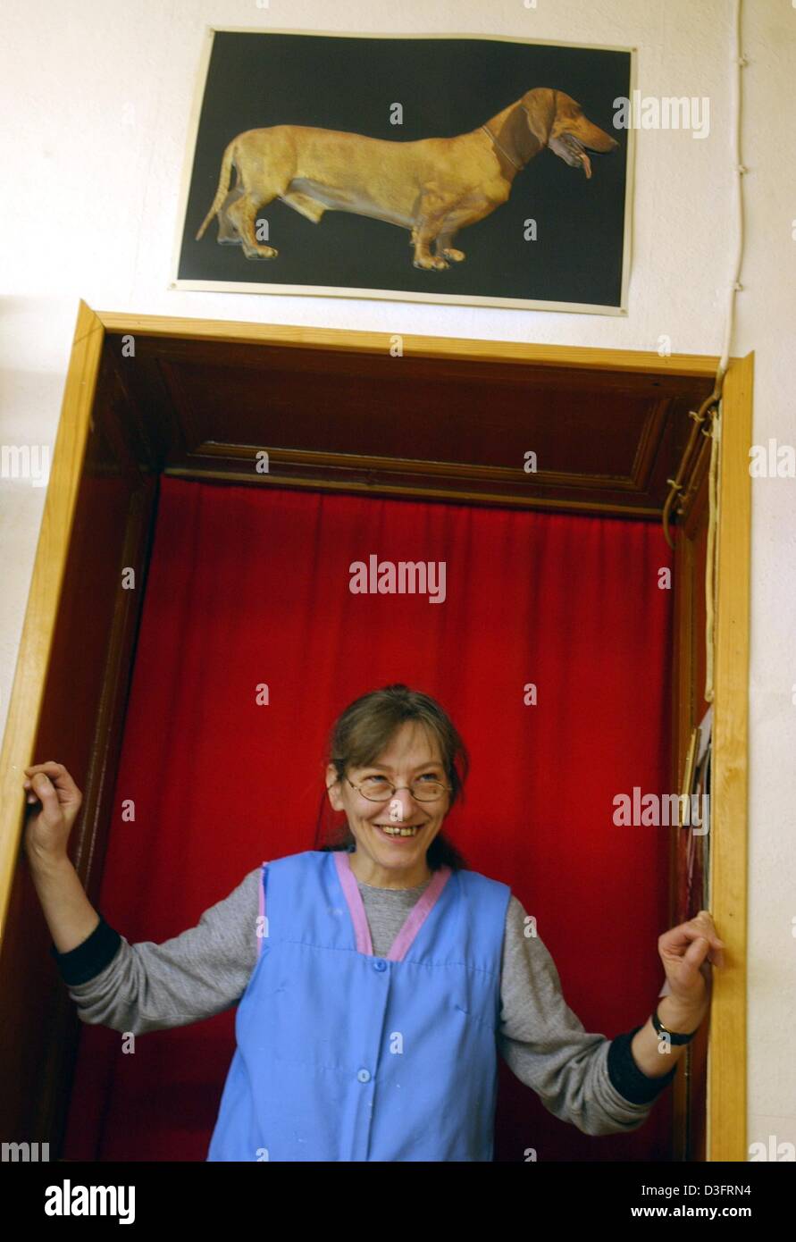 (Dpa) - Christel Balfanz sorge nel vano della porta e sorrisi presso il salone di bellezza per cani 'Exquisit" di Berlino, 12 febbraio 2003. Il proprietario del cane e di estetista, Christel Balfanz è stato acceso il suo negozio a partire dal 1971. Ella riceve una media di quattro o cinque cani al giorno e tasse 10 euro all'ora. Spesso la gente che lavora a goccia a al mattino e lasciare i loro cani con lei fino a quando essi col Foto Stock