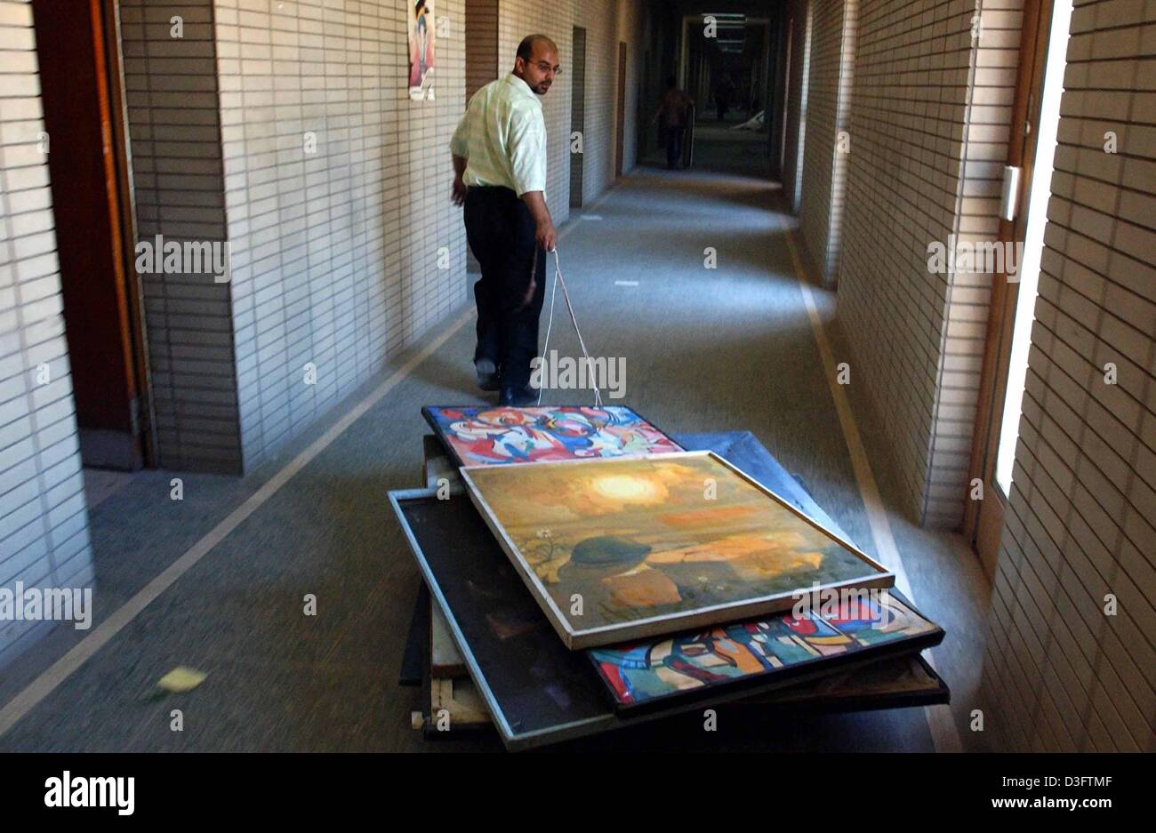 (Dpa) - Un dipendente si sposta un paio di immagini attraverso la sala di Iraqi National Museum di Baghdad, 29 aprile 2003. Più di 600 opere d'arte rubate che era stato rubato dai saccheggiatori sarebbe tornato al museo, i funzionari statunitensi detto il 29 aprile. Foto Stock