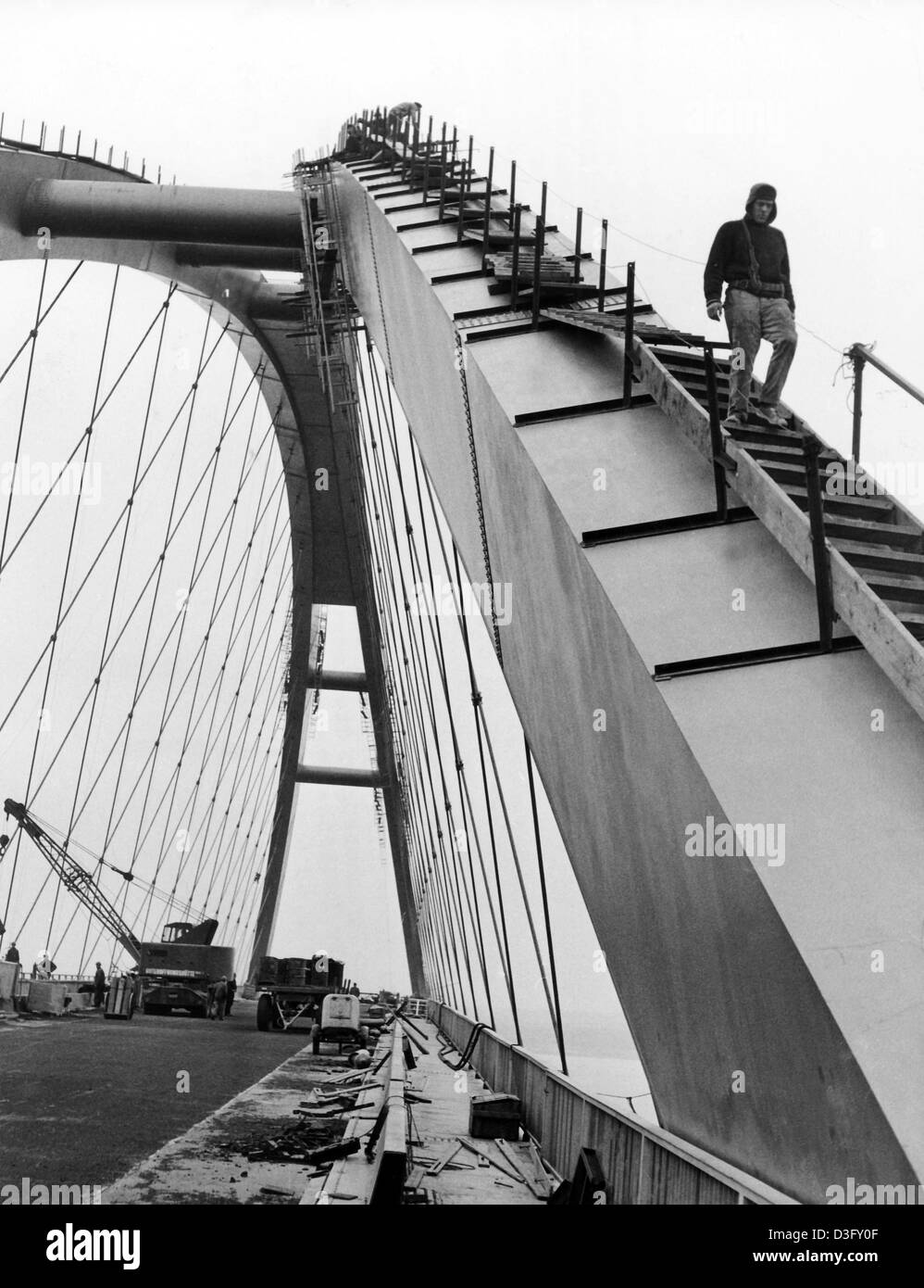 Costruttori fare gli ultimi lavori sul ponte di archi in aprile 1963. Tramonto dietro il ponte non datata (foto). Il ponte attraverso il Fehmarn suono nel Mar Baltico collega la terraferma con l'isola Fehmarn. La strada combinato e ponte ferroviario è stato aperto al pubblico il 30 di Aprile di 1963. Foto Stock