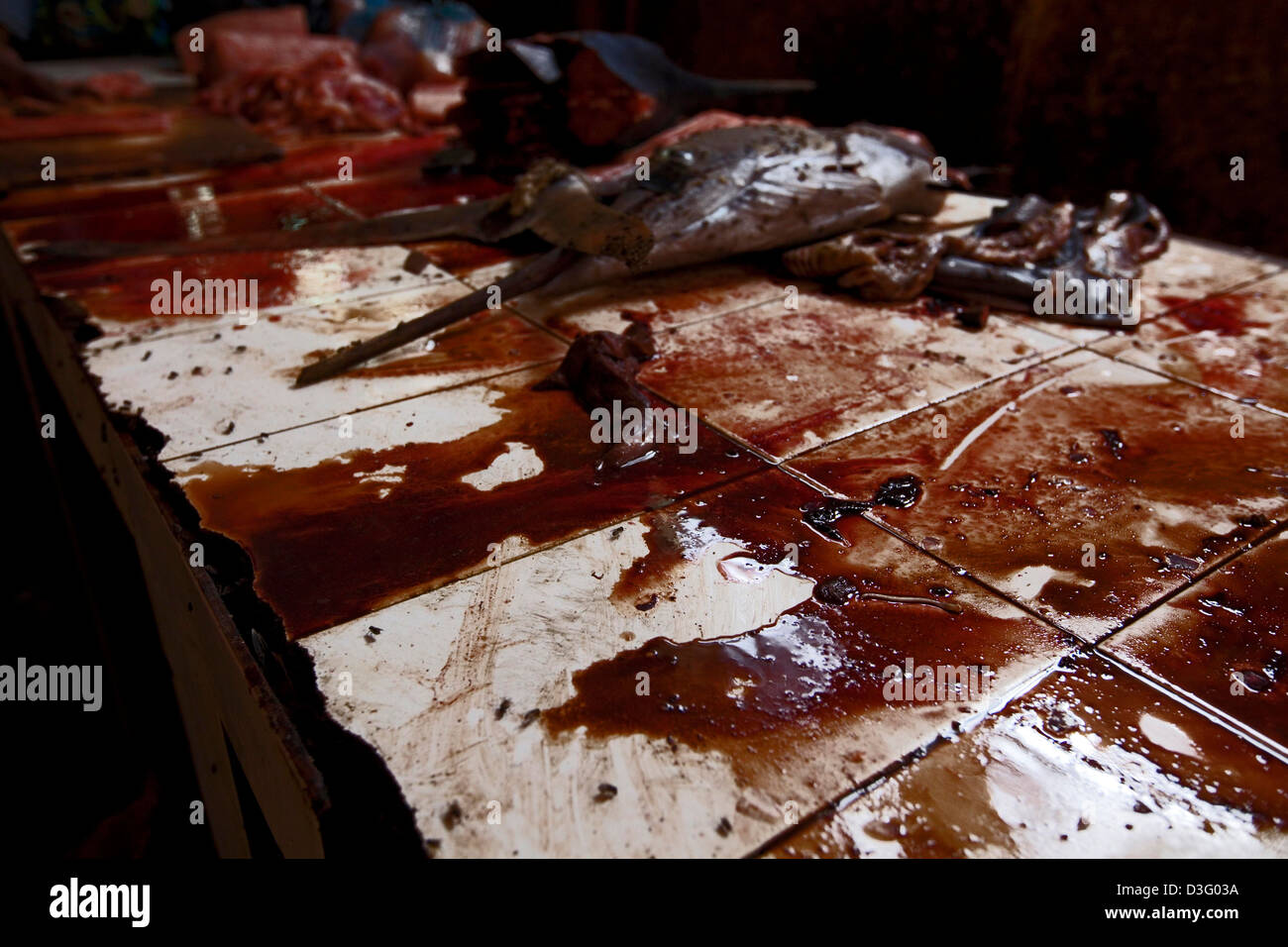 Un'eviscerazione e la tabella di pulizia coperto di sangue di pesce con una testa di pesce spada giacente in background al mercato del pesce di Mogadiscio Foto Stock