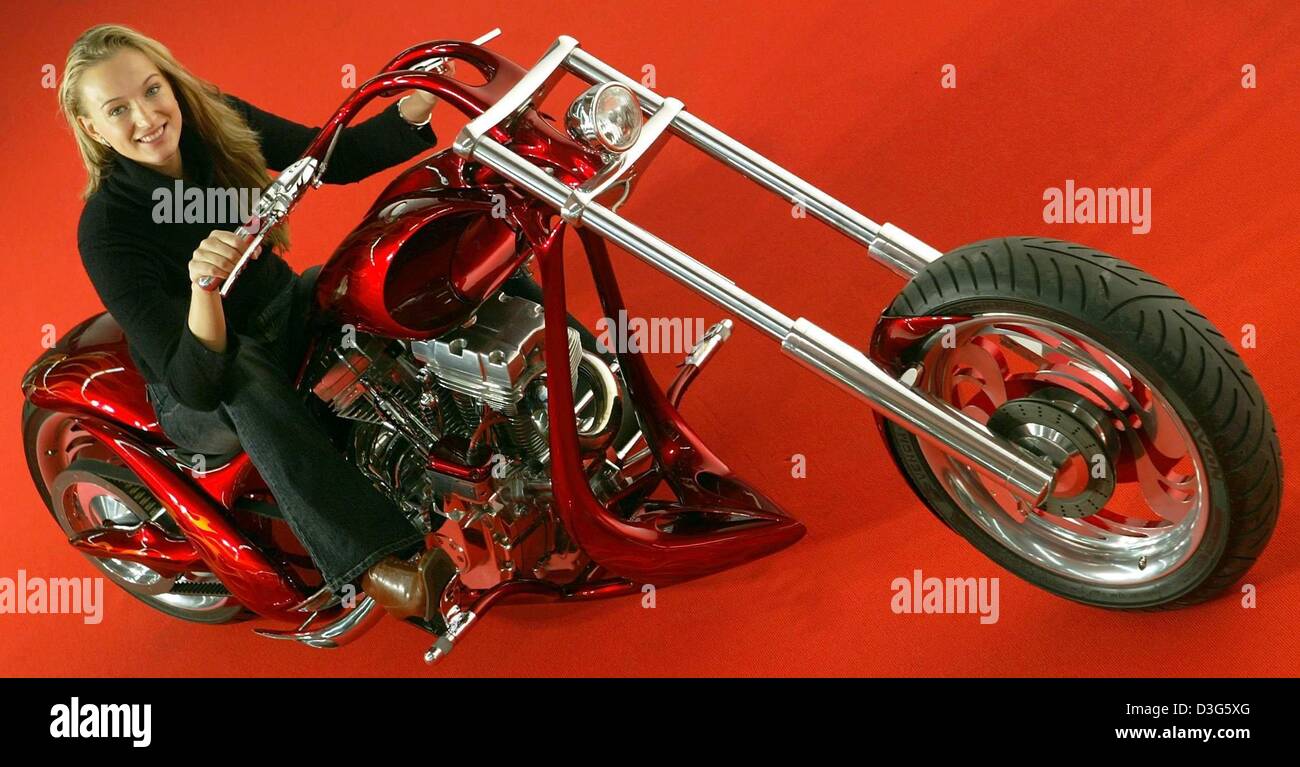 (Dpa) - Il modello Xenia si siede su un 'atanical pandemonio' motocicletta e pone a opportunità di una foto durante il Motor Show 2003, fiera per la sintonizzazione, Motorsport e classici, a Essen, Germania, 24 novembre 2003. Il 'Satanical pandemonio" è stato costumised da Nicolas Chauvi, un belga Top-Costumizer per motociclette e auto. Il motorcylce consiste di una Harley-Davidson-Twin-Cam Foto Stock