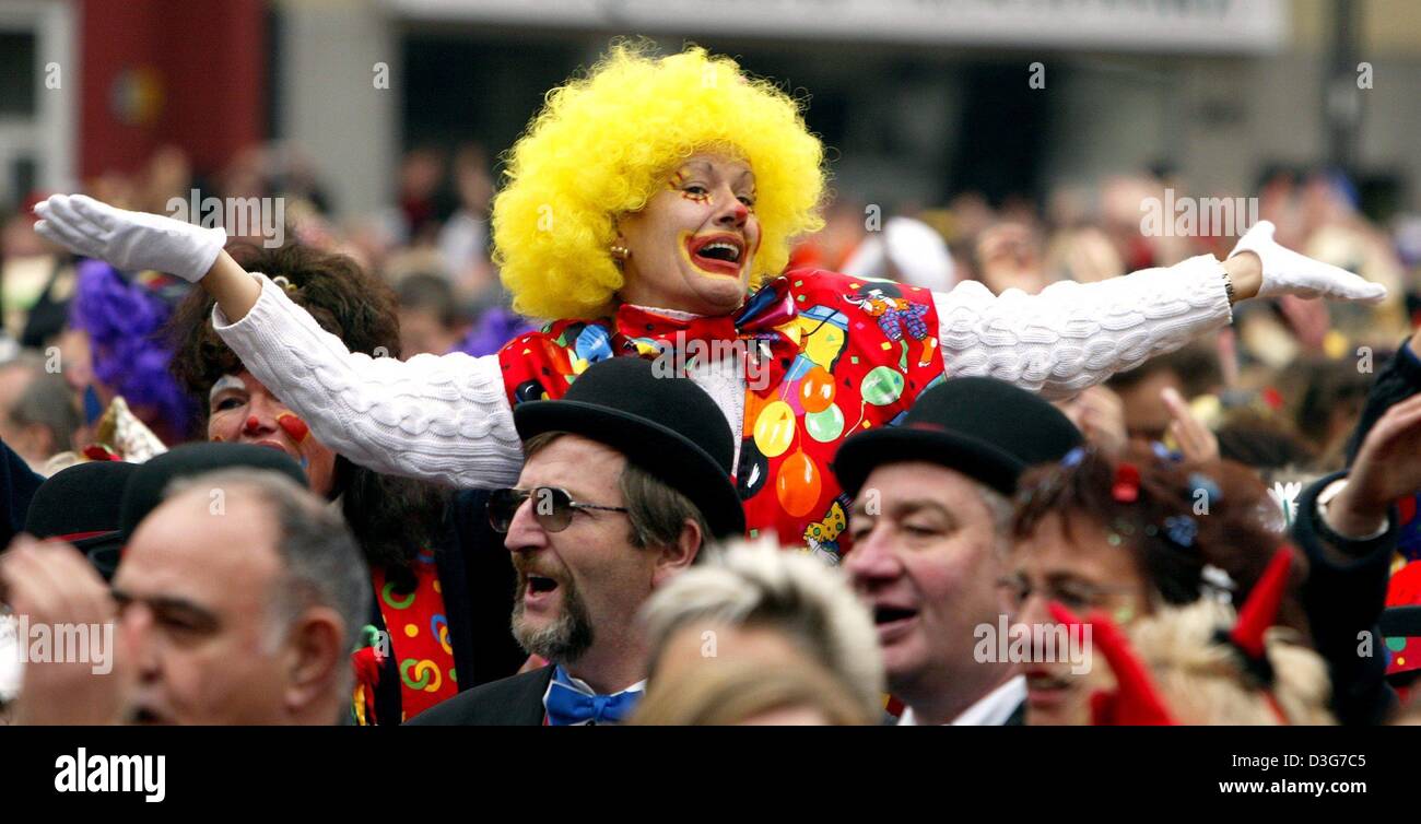 (Dpa) - Un carnevale fallo vestito in un costume da clown alza le braccia e saluti tra un felice folla di diverse migliaia di carnevale celebrando la gente sulla "Alter Markt" (piazza del mercato vecchio) a Colonia, Germania, 11 novembre 2003. Stagione di carnevale in Germania inizia tradizionalmente il 11 novembre a 11:11 am. Diverse migliaia di persone si sono riunite nelle strade per festeggiare questo Foto Stock