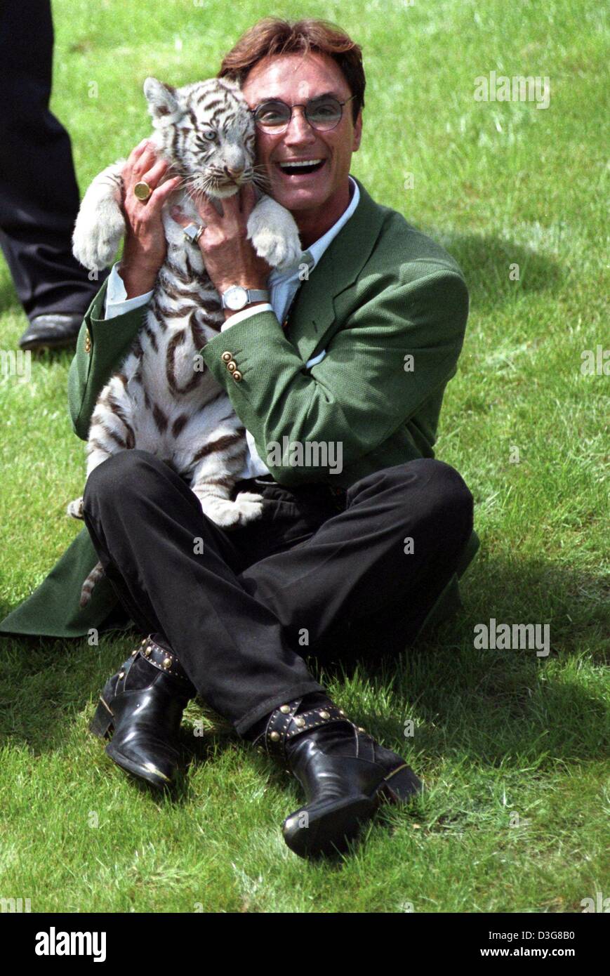 (Dpa file) - Roy corno dell'animale mago duo Siegfried e Roy, gioca con una tigre bianca a Hollywood parco di safari in Stuckenbrock, Germania, 16 gennaio 1997. Roy Horn è recuperare dopo essere stato aggredito da una tigre in scena a Las Vegas il 3 ottobre 2003. Il 59-anno-vecchio tedesco-nato esecutore, è stato morso da un bianco tigre del Bengala nel collo e trascinato fuori dal palcoscenico durante una perfo Foto Stock
