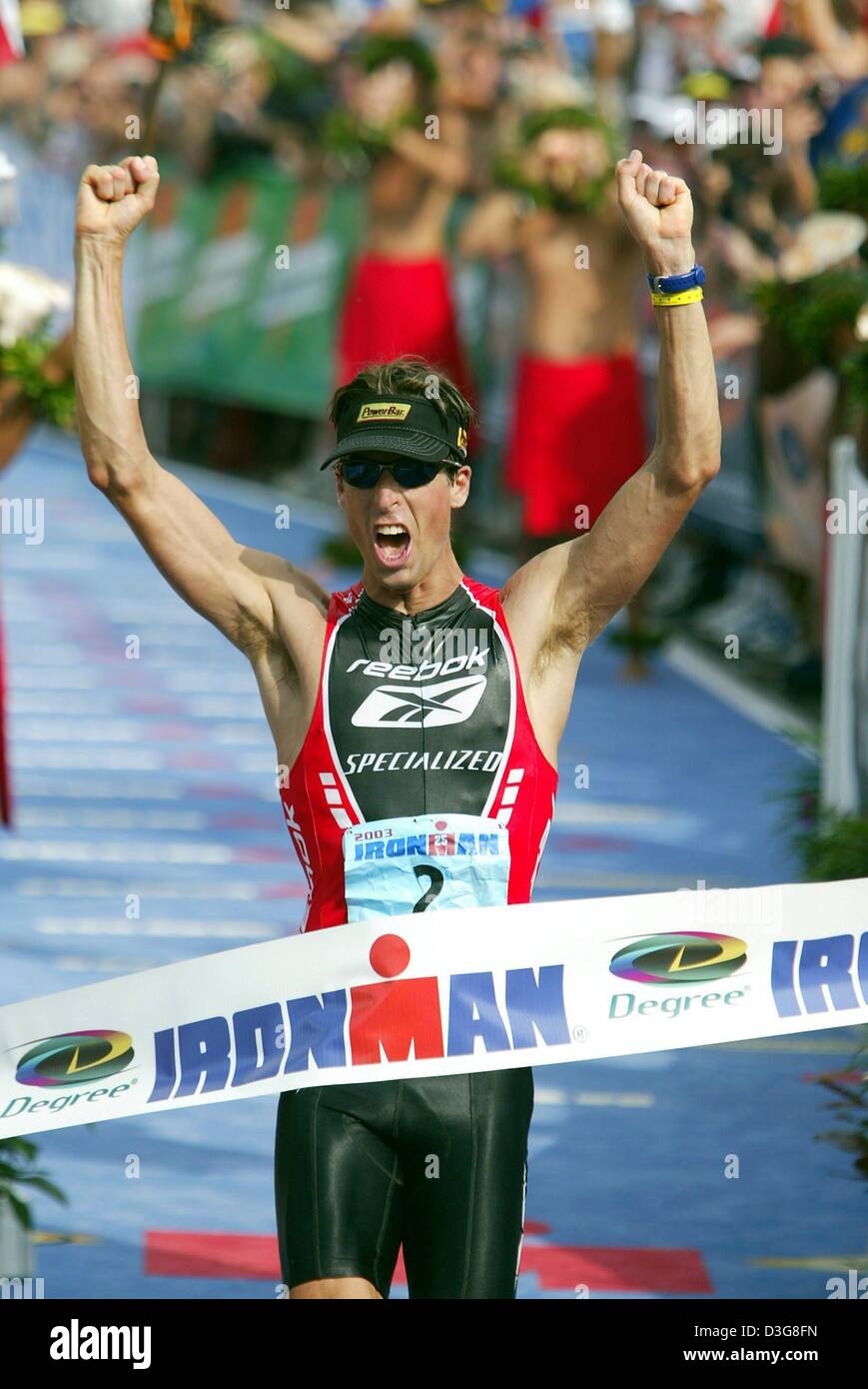 (Dpa) - canadese Peter Reid cheers come egli attraversa la linea del traguardo della 27 l'uomo del ferro la concorrenza in Kailua-Kona, Hawaii, 18 ottobre 2003. Ha vinto gli uomini della temporizzazione degli eventi 8:22:36 ore. L'evento comprendeva 3.8 km a nuoto, 180 km in bicicletta e una maratona di corso. Foto Stock