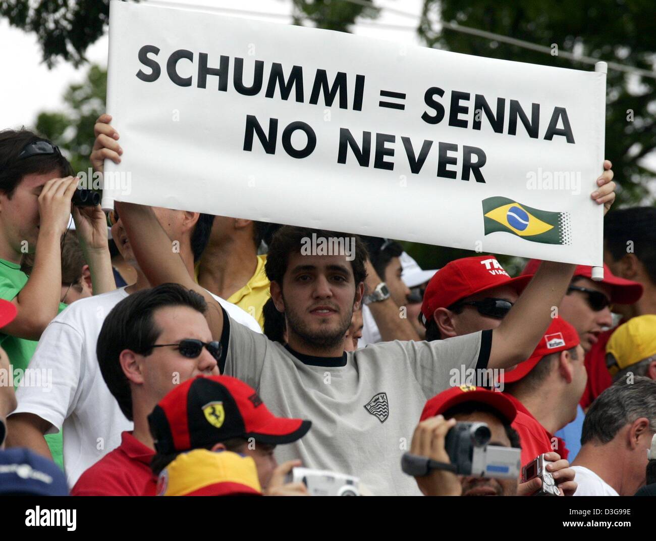 (Dpa) - Un brasiliano Formula una ventola contiene un banner con la scritta "chummi = Senna no mai' nelle sue mani durante il brasiliano FORMULA ONE Grand Prix sul circuito di Interlagos in Sao Paulo, Brasile, 24 ottobre 2004. Brasiliano della Formula Uno il campione del mondo Ayrton Senna che morì in un incidente e tedesco di Formula Uno del campione del mondo in carica Michael Schumacher (Ferrari) sono spesso paragonato wit Foto Stock