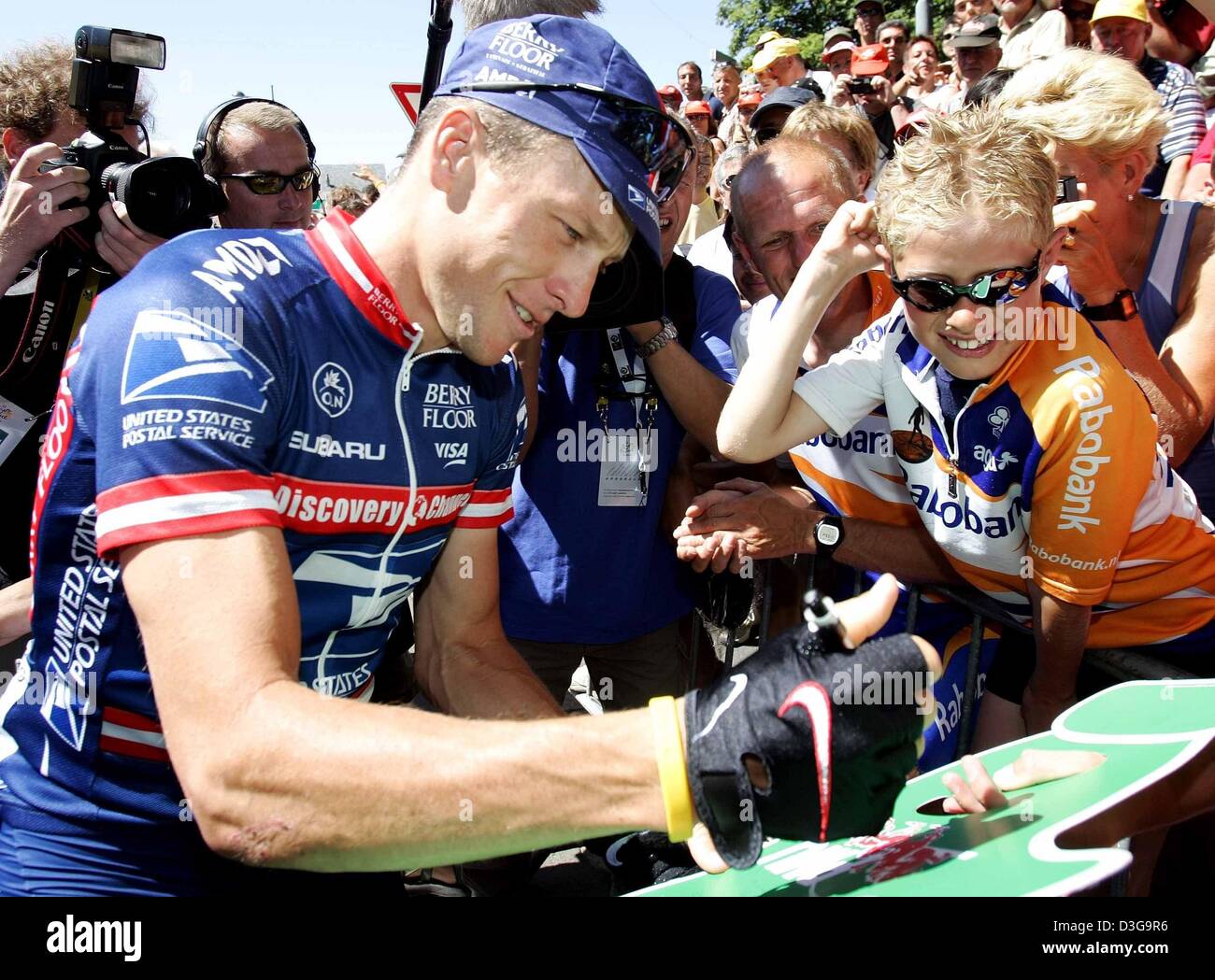 (Dpa) US Postal team rider e cinque volte vincitore del Tour de France Lance Armstrong da noi segni autografi come fa il suo modo attraverso la folla di spettatori e fotografi prima l'undicesima tappa del Tour de France ciclismo gara di Saint-Flour, Francia, 15 luglio 2004. La 164km lunga tappa conduce i ciclisti da Saint-Flour a Figeac. Foto Stock