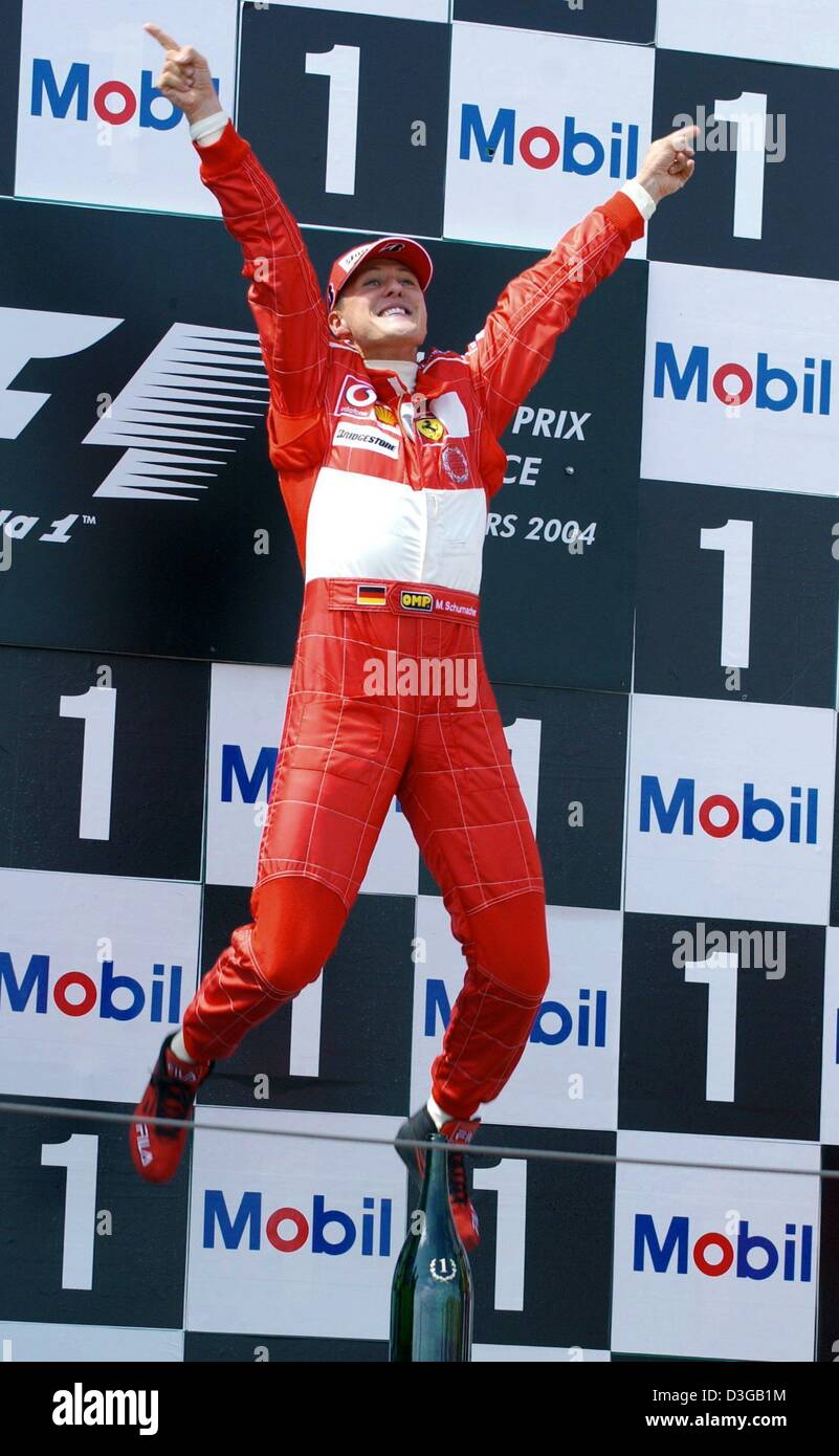 (Dpa) - Tedesco pilota di Formula Uno Michael Schumacher (Ferrari) salti di gioia dopo aver vinto il Gran Premio di Francia in Magny Cours racing corso in Francia, il 4 luglio 2004. Il sei volte campione del mondo Schumacher ha vinto la sua nona gara della stagione, matching il suo record di sette vittorie in una sola gara. Ora egli è anche proprietaria della prima vittoria in F1 con quattro deliberata di pit-stop. Foto Stock