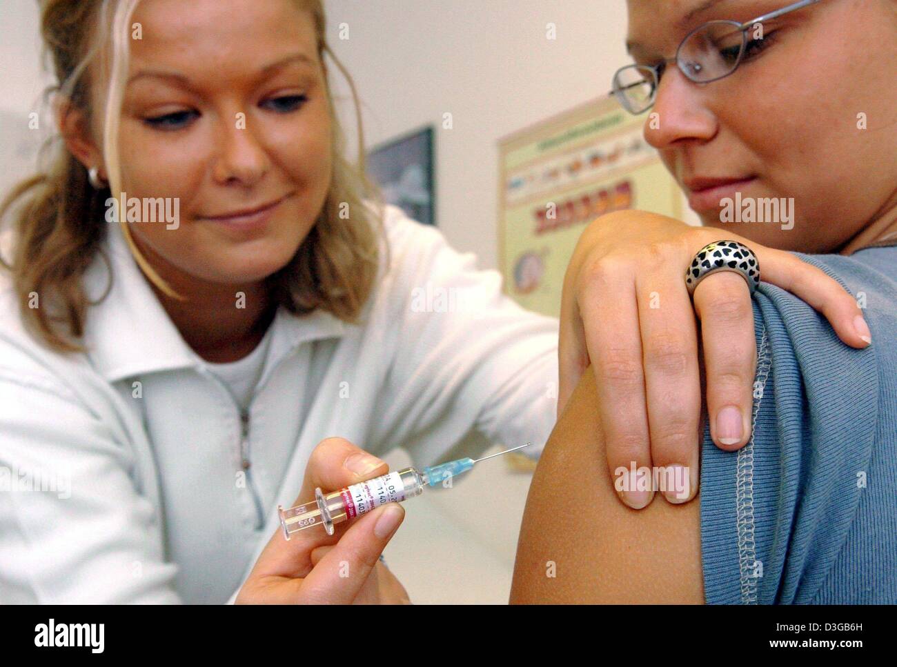 (Dpa) - assistente medico Jeannine Paulicke dà Jana Ballin un influenza la vaccinazione a un ambulatorio medico a Francoforte/Oder, Germania, 29 ottobre 2004. Il Team aviaria (AGI) si aspetta una grave ondata di influenza per il 2004/2005 dopo un piuttosto mite ondata di influenza nel 2003/2004. In particolare le persone di età superiore a 60 anni, malati cronici e personale medico dovrebbe ottenere la vaccinazione. Foto Stock